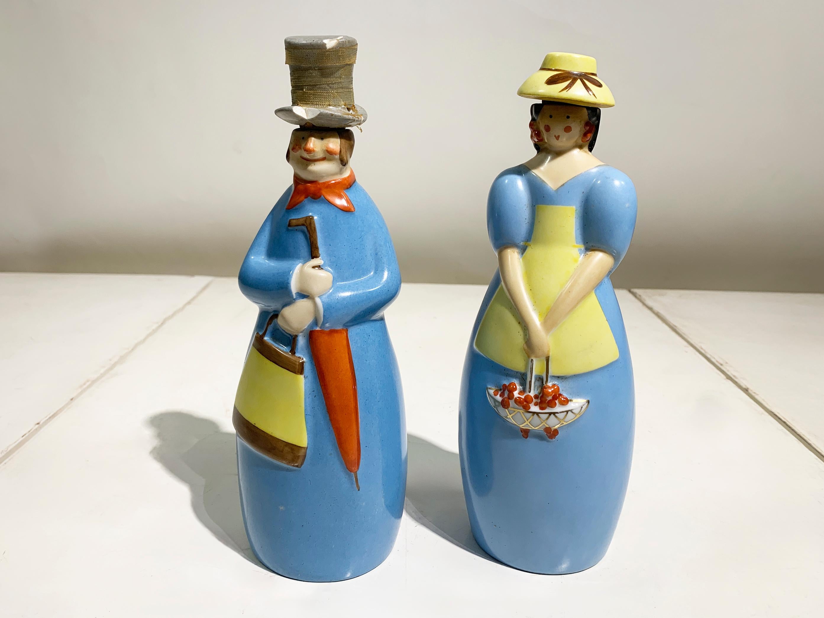 A charming and whimsical set of two original French Art Deco enameled porcelain liqueur bottles (flacons à liqueur) produced by the highly sought after firm of Robj Paris during their most prolific period.

These figures are celebrated examples of