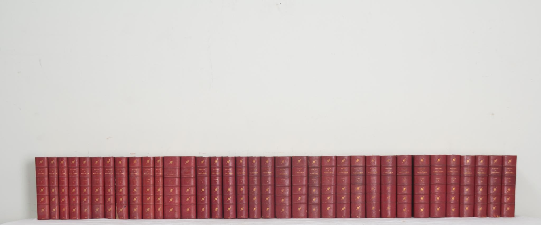 Une collection de vingt-deux volumes des œuvres de Molière et de Saint-Simon. Cette série de livres est reliée en cuir avec des lettres dorées indiquant l'auteur et le volume correspondant. Rédigés entre 1873 et 1910, Les Grands Écrivains de la