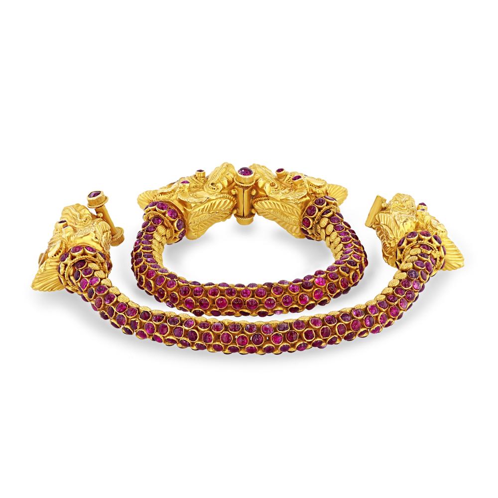 This striking pair of 22k+ yellow gold, ruby, and diamond “dragon” bracelets are a vintage masterpiece. The unique design allows for flexible movement down the ruby covered collars and bodies of the dragon's, and their heads are topped off with