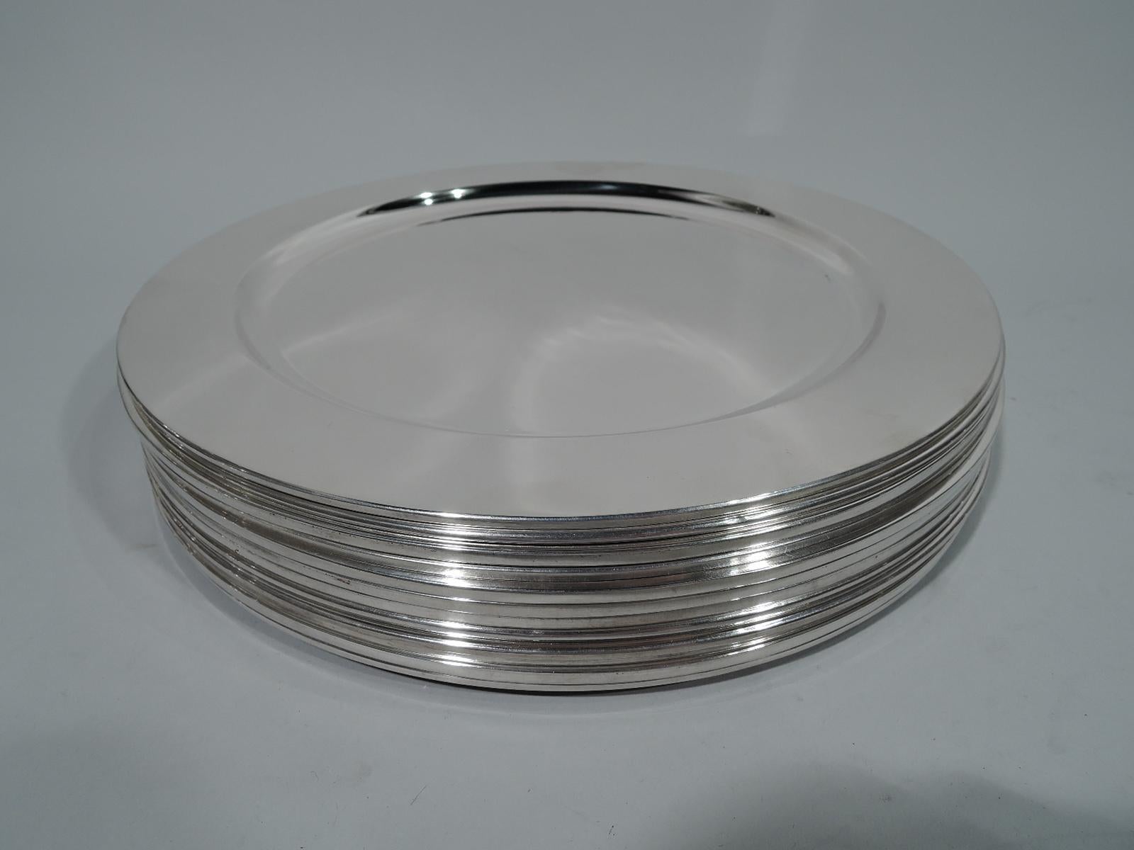 Set of 24 modern sterling silver plates. This set comprises 12 dinner plates and 12 bread-and-butter plates: Each: Well with wide and flat shoulder. Spare and functional with well-defined form. Mexican hallmarks with 1960s-1970s eagle stamp.
