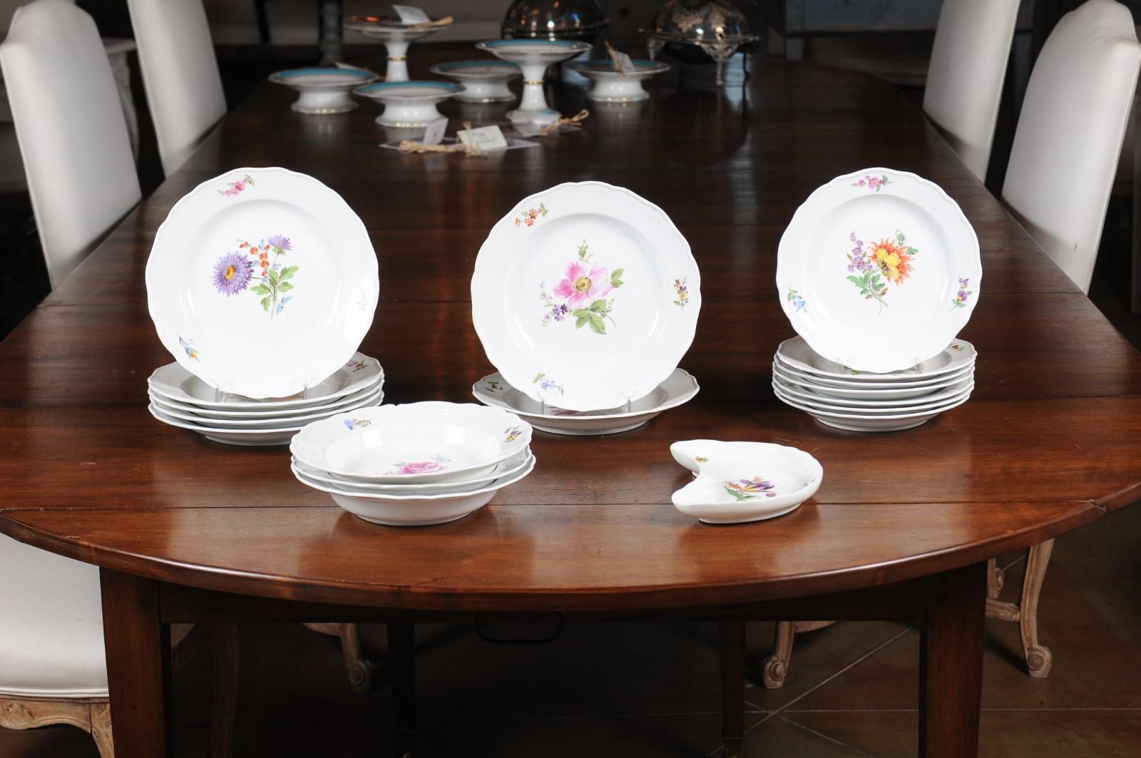 A 24-piece set of German Meissen porcelain service from the 19th century, with floral decor. Born in Eastern Germany during the 19th century, each of this 24 pieces service features a lovely floral décor made of purple, pink, orange or yellow
