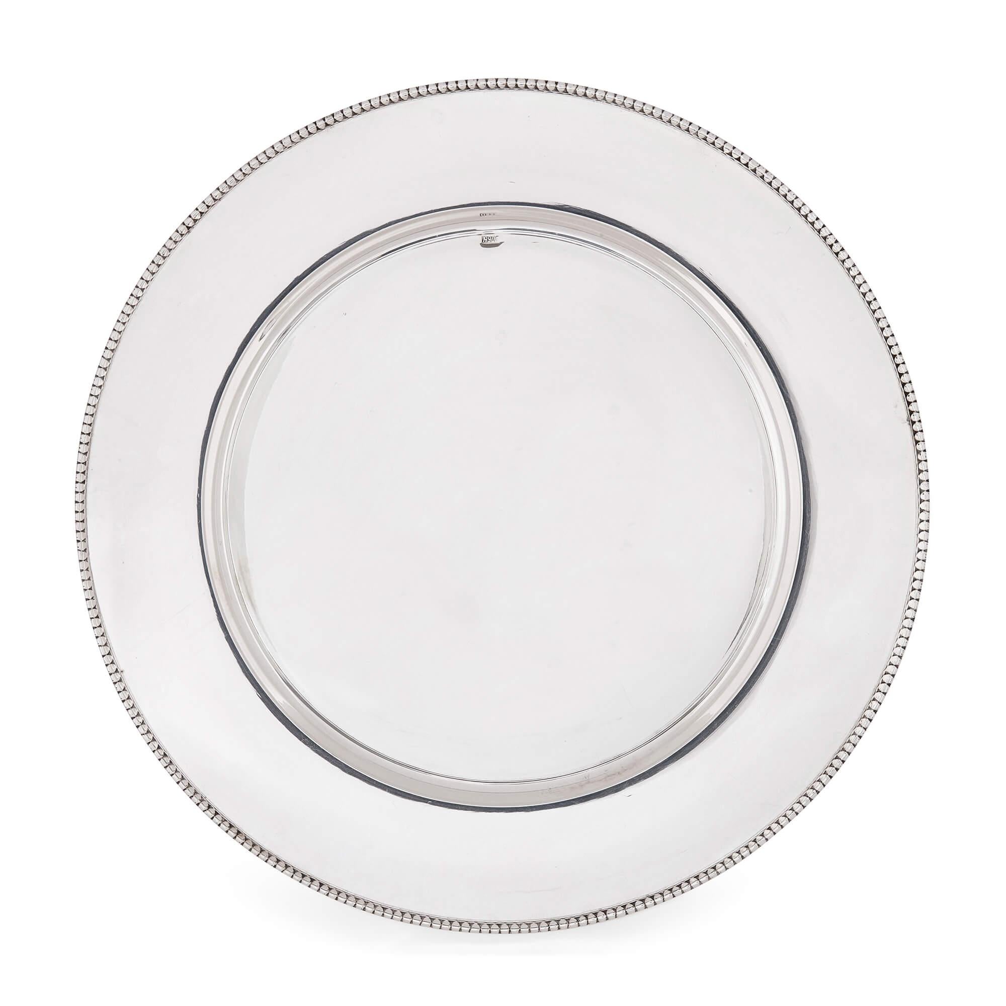 Set of 24 silver underplates 
Continental, 20th Century 
Height 1.5cm, diameter 30cm

This very refined set of twenty-four underplates (also called charger plates) was crafted in the 20th century. Entirely made from silver, this set would make a