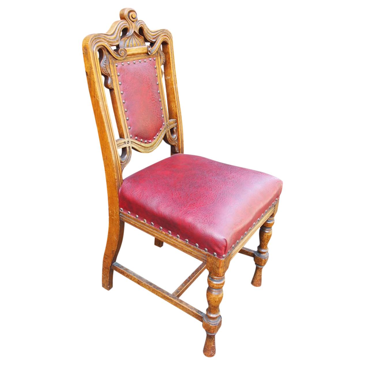 Circa 1880, set of 24 carved oak dining chairs, with 23 side chairs and 1 large armchair. They have a carved top rail and a padded back in the oak frame with a large stuffover seat. The front and side rails are ribbed and it stands on turned and