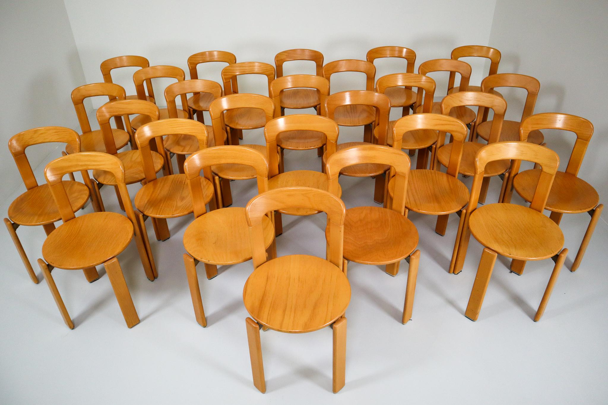 The set of 28 dining room chairs were designed by Bruno Rey for Kusch and Co., 1970s. The dining room chairs were made of solid beech, laminated plywood beech and cast aluminum, characteristic steel brackets support wooden round seat. These chairs
