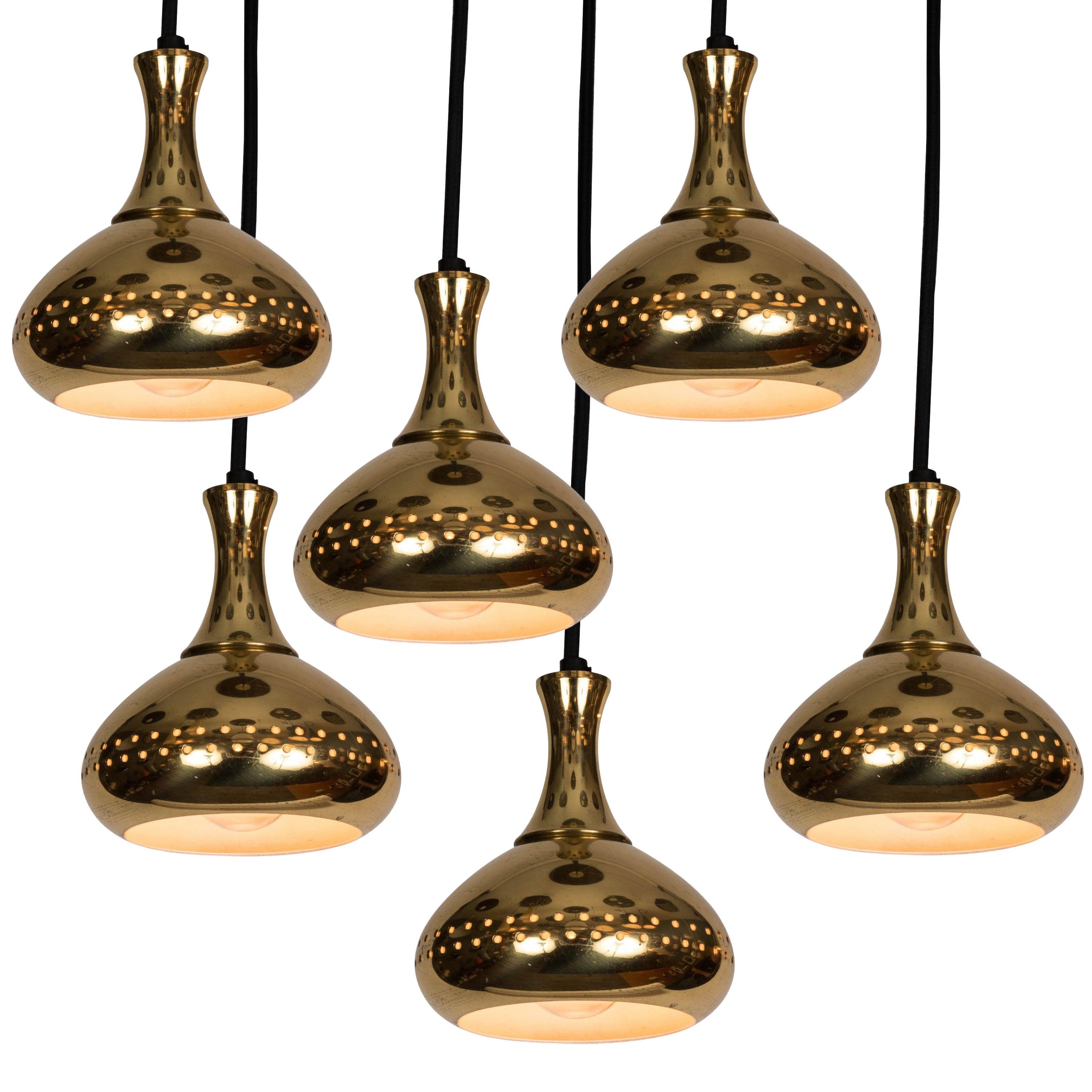 1950s Hans-Agne Jakobsson perforated brass pendants for Markaryd, Sweden. Graced with simple Scandinavian curves and pleasing brass patina. Professionally rewired for US electrical. Height is readily adjustable to desired length. Original