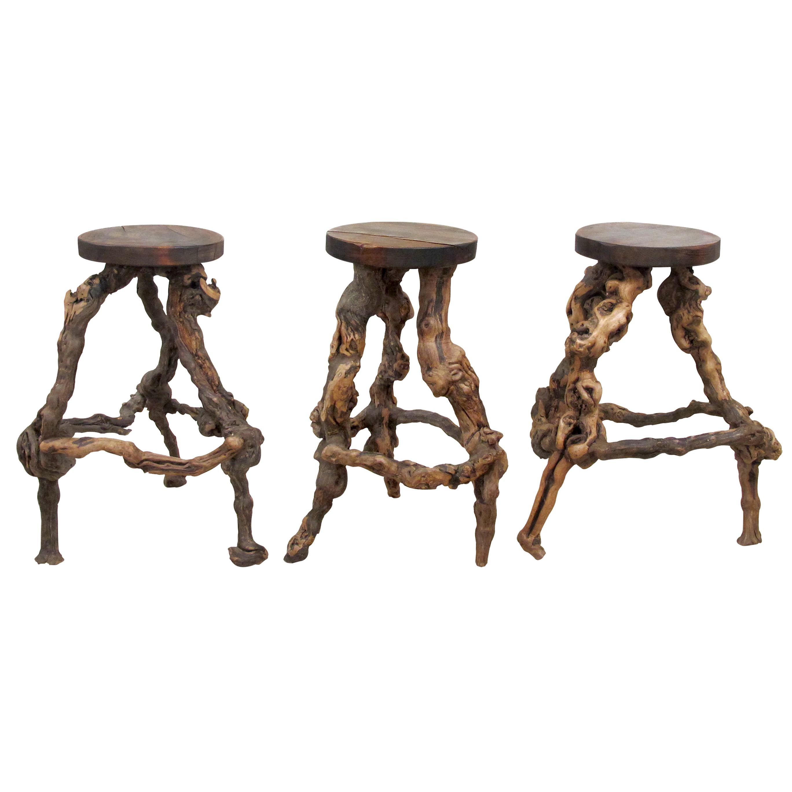 A set of 3 French mid century grapevine bar stools. These unique stools have been handcrafted individually; the base is made of naturally twisted vine roots; therefore, each stool is unique. The stools have acquired a nice patina commensurate with