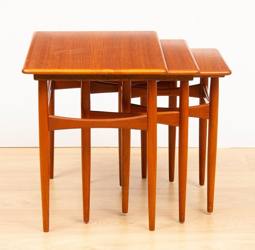 Satz von 3 dänischen Teakholz-Nesttischen aus den 1960er Jahren:: entworfen von Poul Hundevad und hergestellt von Fabian in Dänemark. Die Tische sind mit Gleitschienen an der Unterseite der beiden größeren Tische ausgestattet:: so dass sie bei
