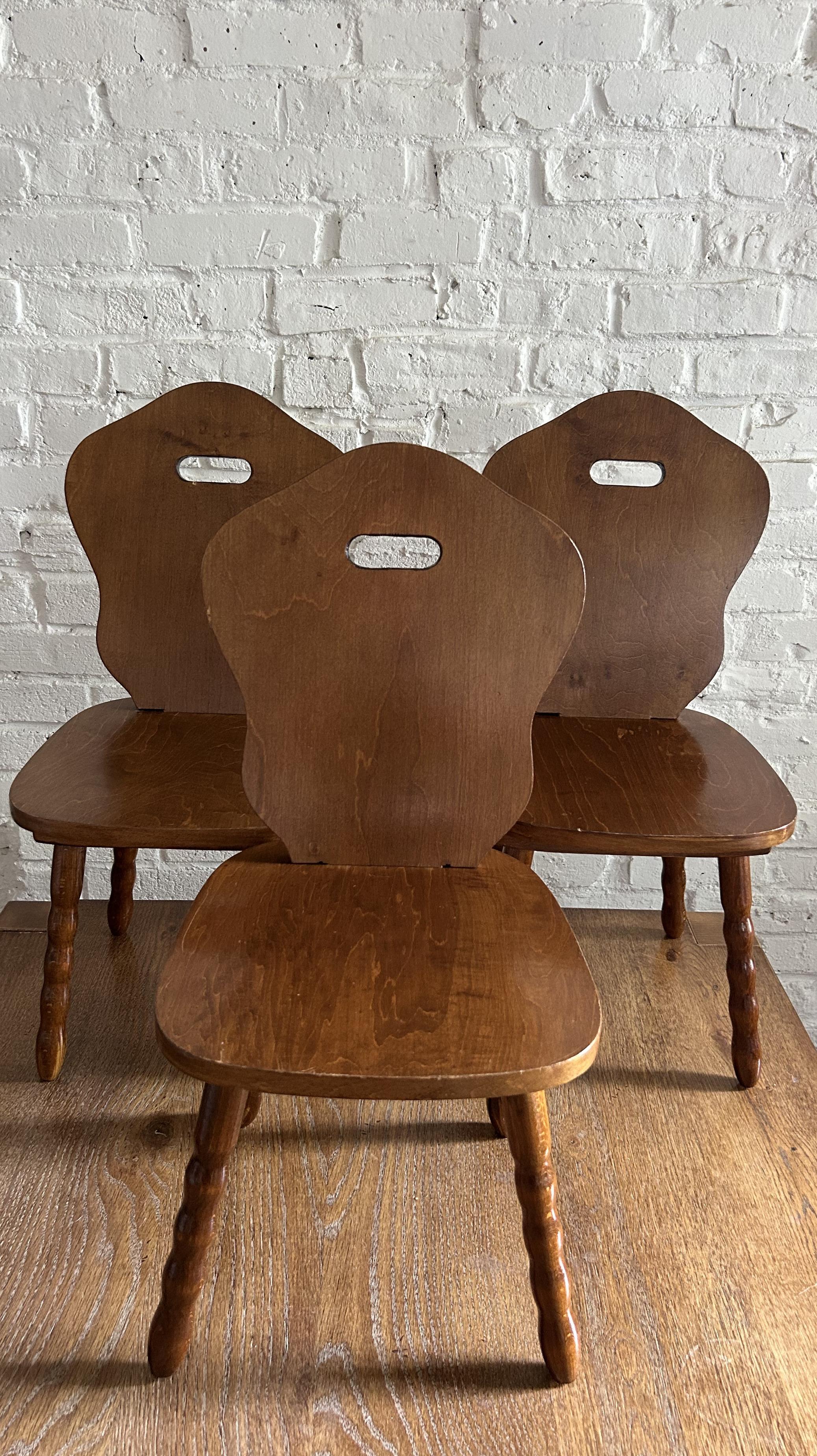 Set of 3 adorable solid wood children's chairs. Features a carved solid back and seat atop four turned legs. While originally a children's chair, they would be best now as a decorative stool in a living room, entry way, bedroom or bathroom. The