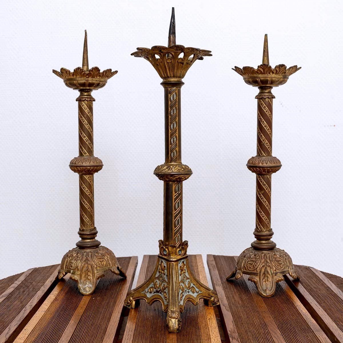 Un charmant ensemble de trois chandeliers d'autel en bronze.
À l'origine, les chandeliers reposaient généralement sur trois pieds, surmontés d'un nœud et d'une mèche pour contenir la cire.
Au centre de cette coupe se trouve une pointe sur laquelle