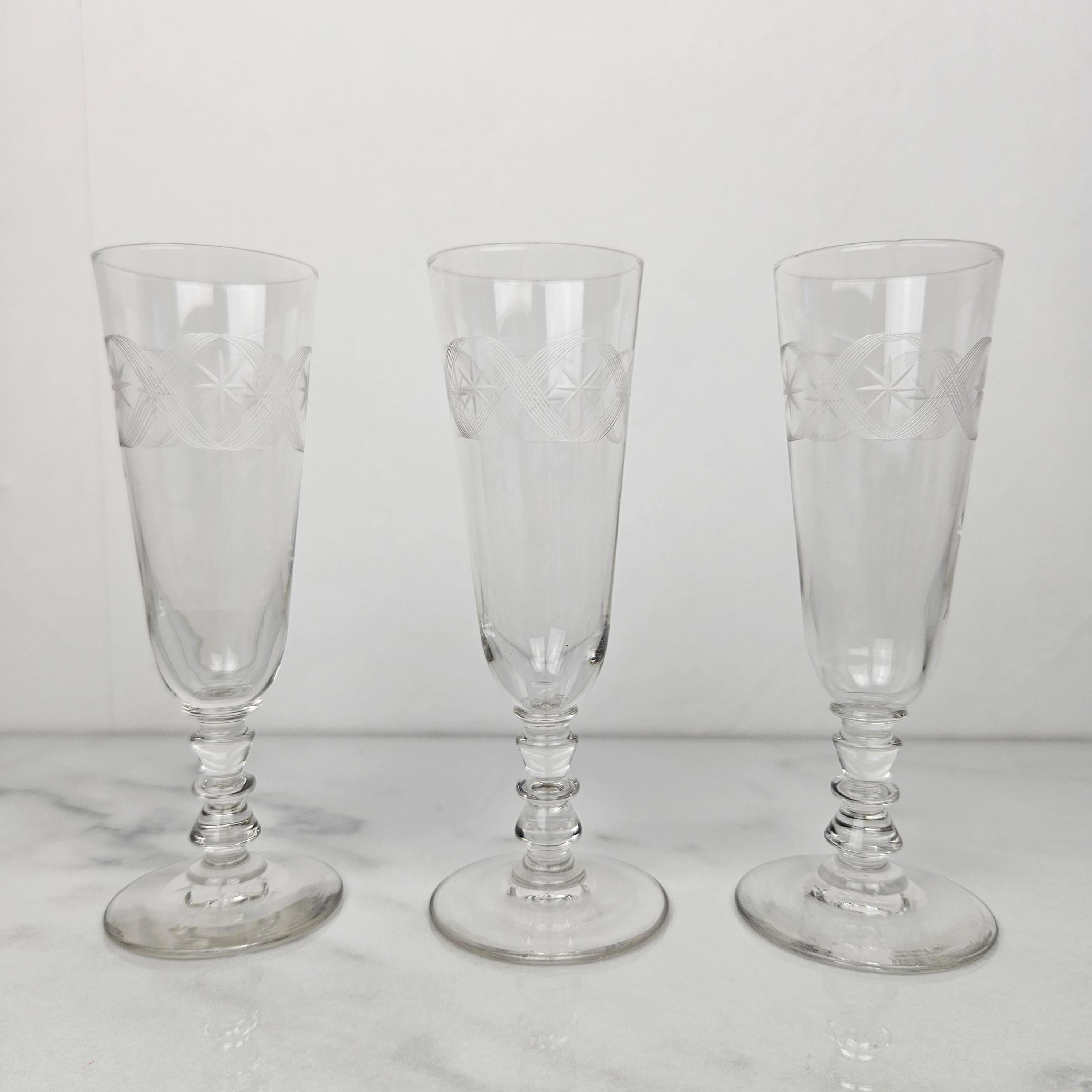 Cet élégant ensemble de trois flûtes à champagne, daté d'environ 1890, respire la sophistication intemporelle.
Chaque verre est délicatement gravé à la main d'un motif complexe d'étoiles et de bandes croisées qui captent magnifiquement la lumière.