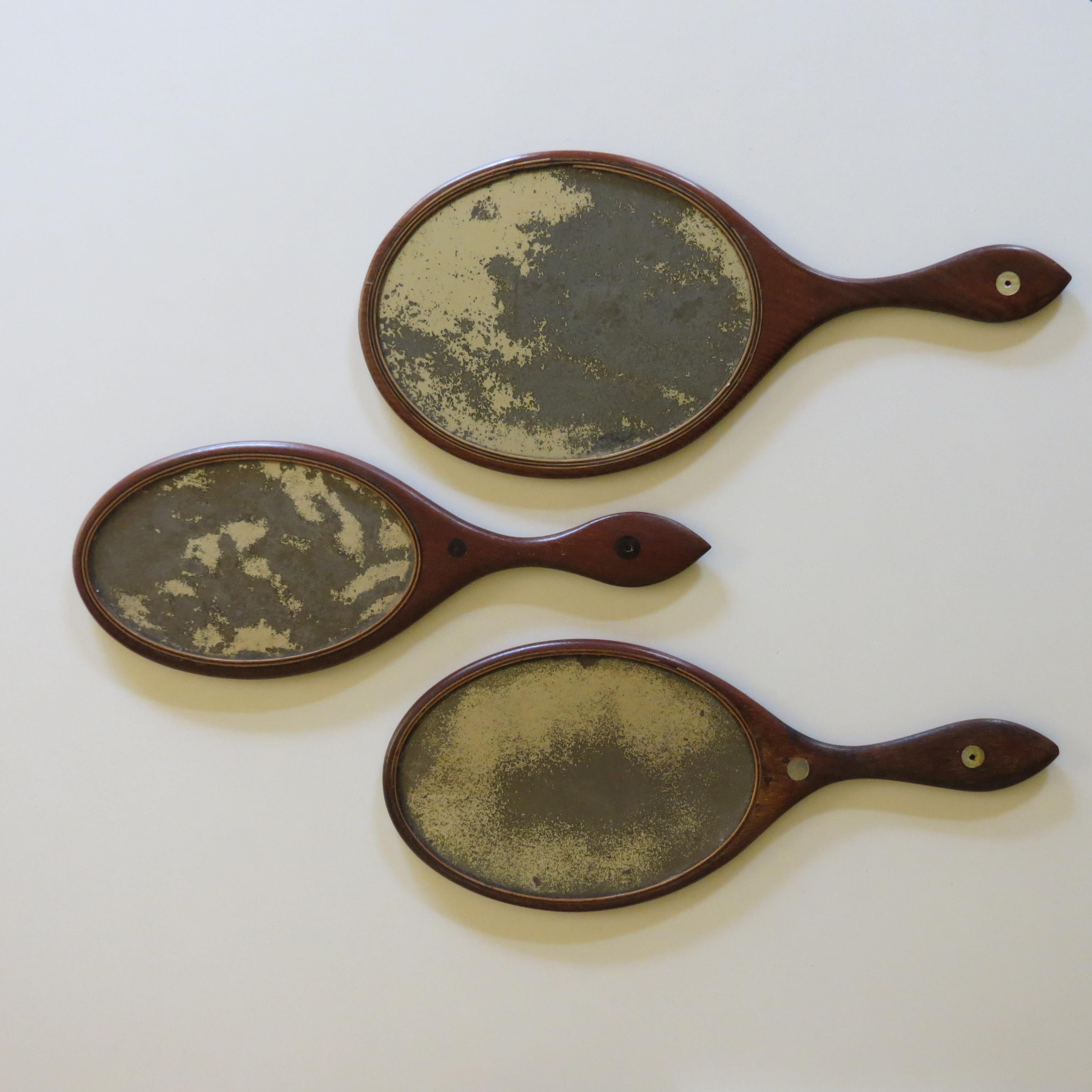 Wonderful set of elegant hand held mirrors. The frames are made from Mahogany with lovely boxwood stringing around the edge of the glass plate mirrors, two of the mirrors have a very nice inlaid circular disc detail to the handle made from shell and