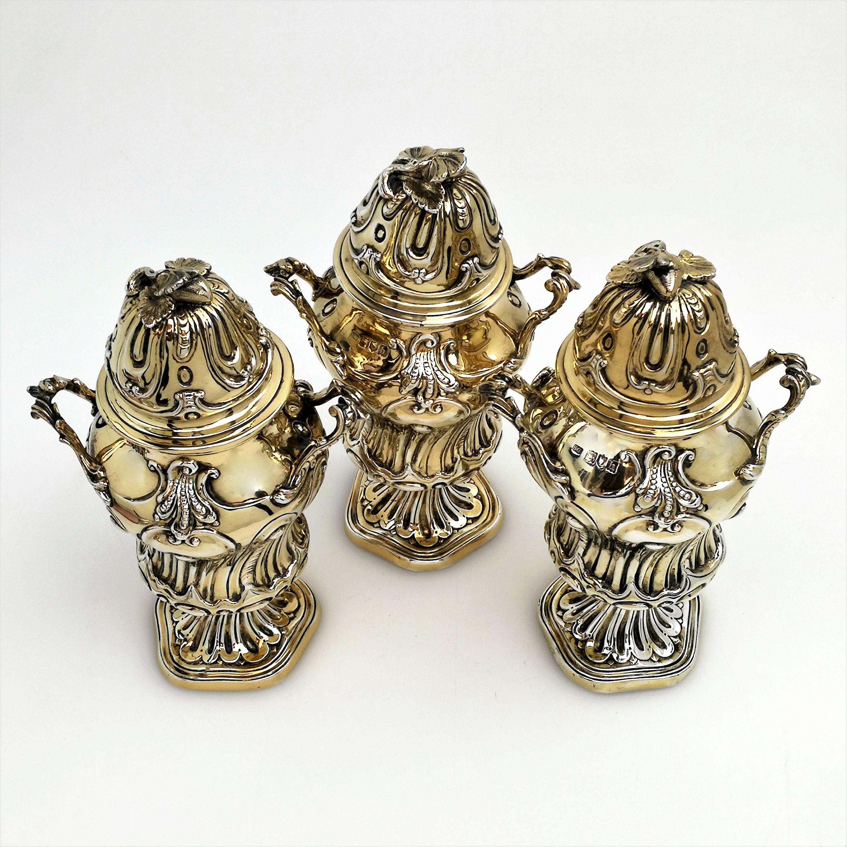 A set of three impressive solid Silver Tea Caddies decorated with ornated chased designs on the body and foot. Each has a chased push fit lid topped with a lovely berry and leaf finial. Each Caddy has a pair of solid handles and each stands on a