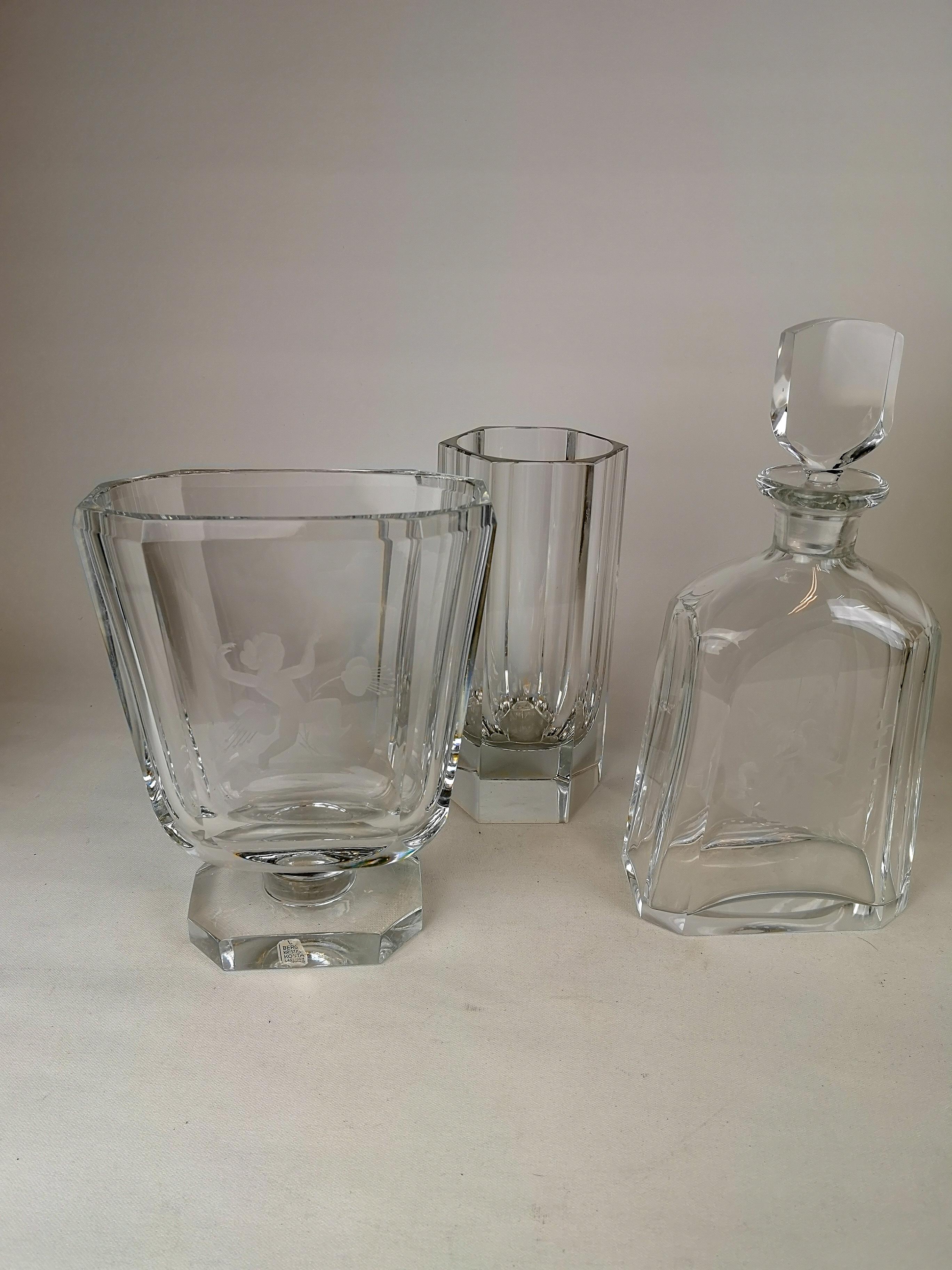 Nice set of 2 vases and one Carafe in Art Deco style. They are all made in Sweden at Kosta and designed by Elis Bergh.
They are nicely finished in the glass and the carafe and one of the vases have nicely pattern carved in to the pieces. 

Good