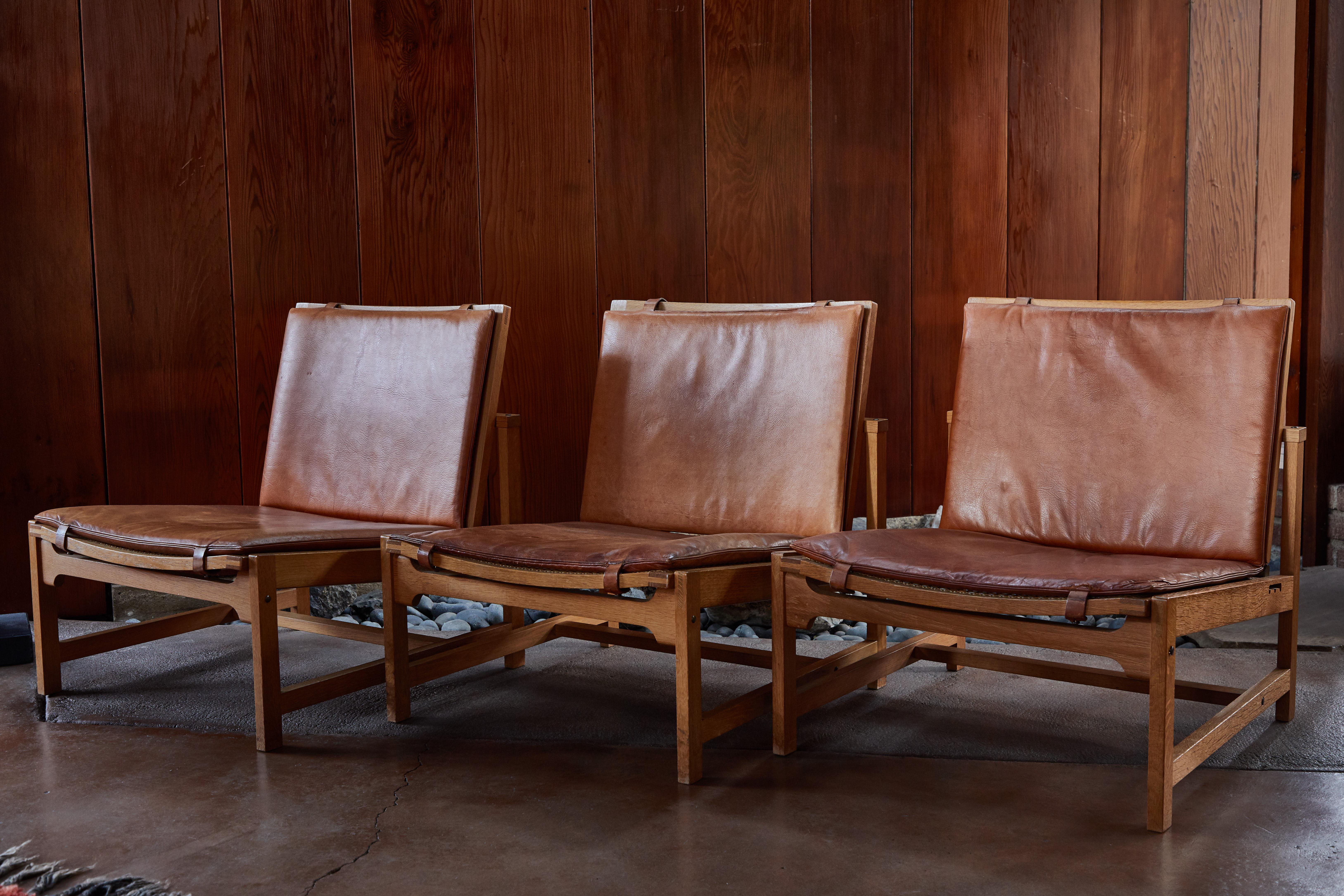Set of 3 Arne Karlsen & Peter Hjort leather and wicker lounge chairs with ottoman. An extremely rare and exceptional set executed in oak with wicker, original cushions upholstered in lovely patinated cognac leather. This Model 12A and 13 were