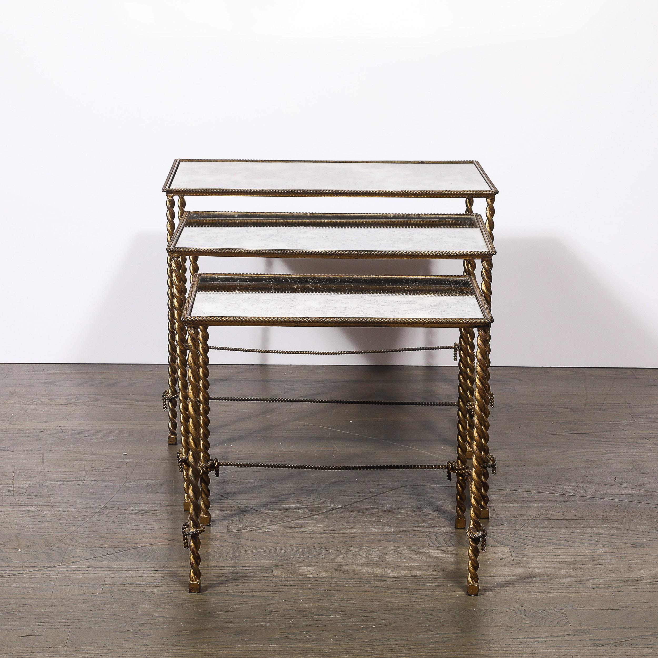 Este exquisito conjunto de tres mesas nido, fabricado en América hacia 1930, ejemplifica la elegancia y sofisticación del diseño Art Déco. Cada mesa es una combinación única de forma y funcionalidad, con intrincados marcos en forma de cuerda de