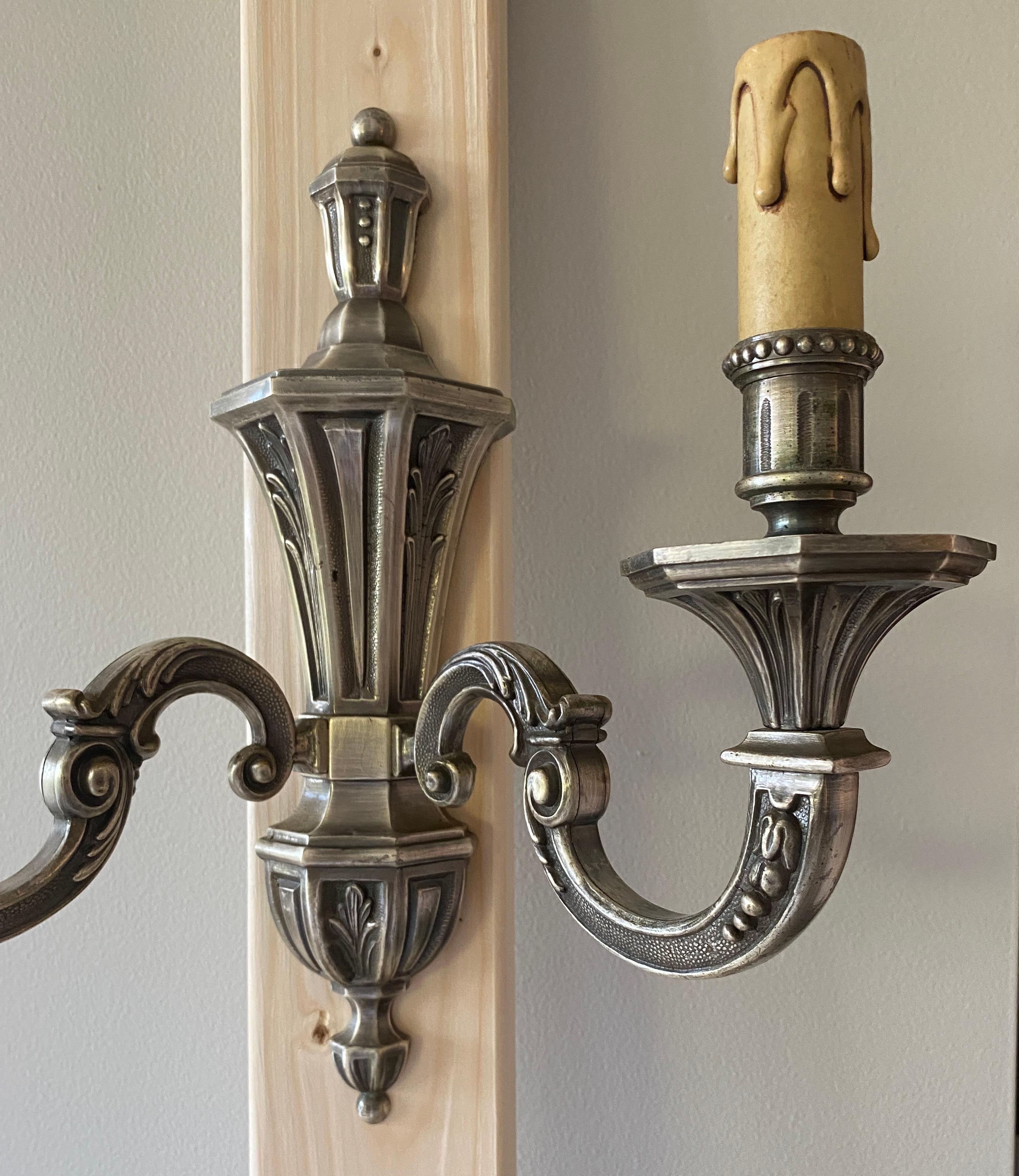 Set of 3 Art Deco or Hollywood Regency style silvered bronze two arm wall sconces.  

Beautiful decorative design, hard wired.
Very good quality and well cast. Stamped.

Dimensions:  
6.38 in. Deep x 12.75