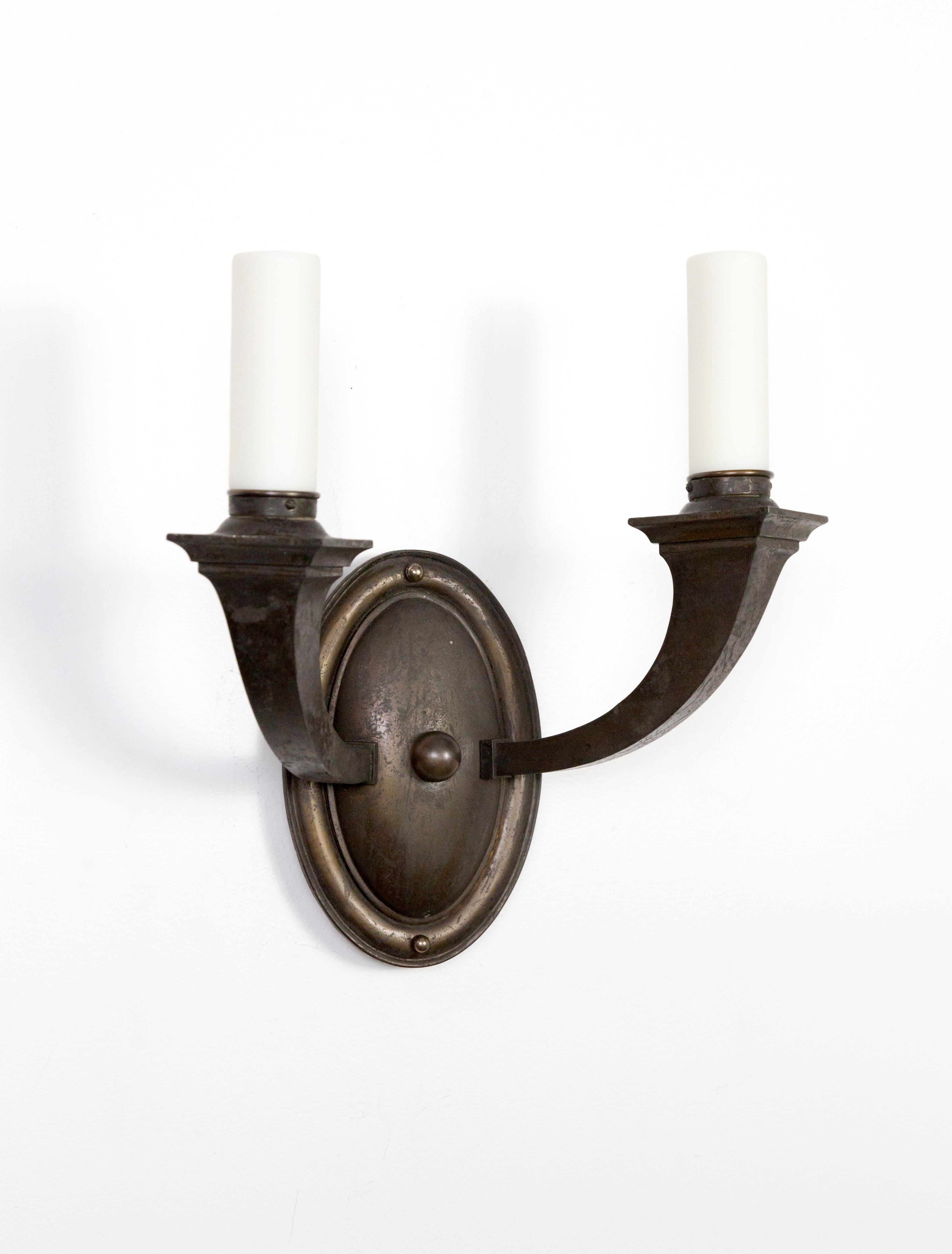 A set of three American, Arts & Crafts, bronze, 2-arm sconces. Egg form escutcheon mounts, with strong, squared off candle supports. Newly rewired. Measures: 13.5