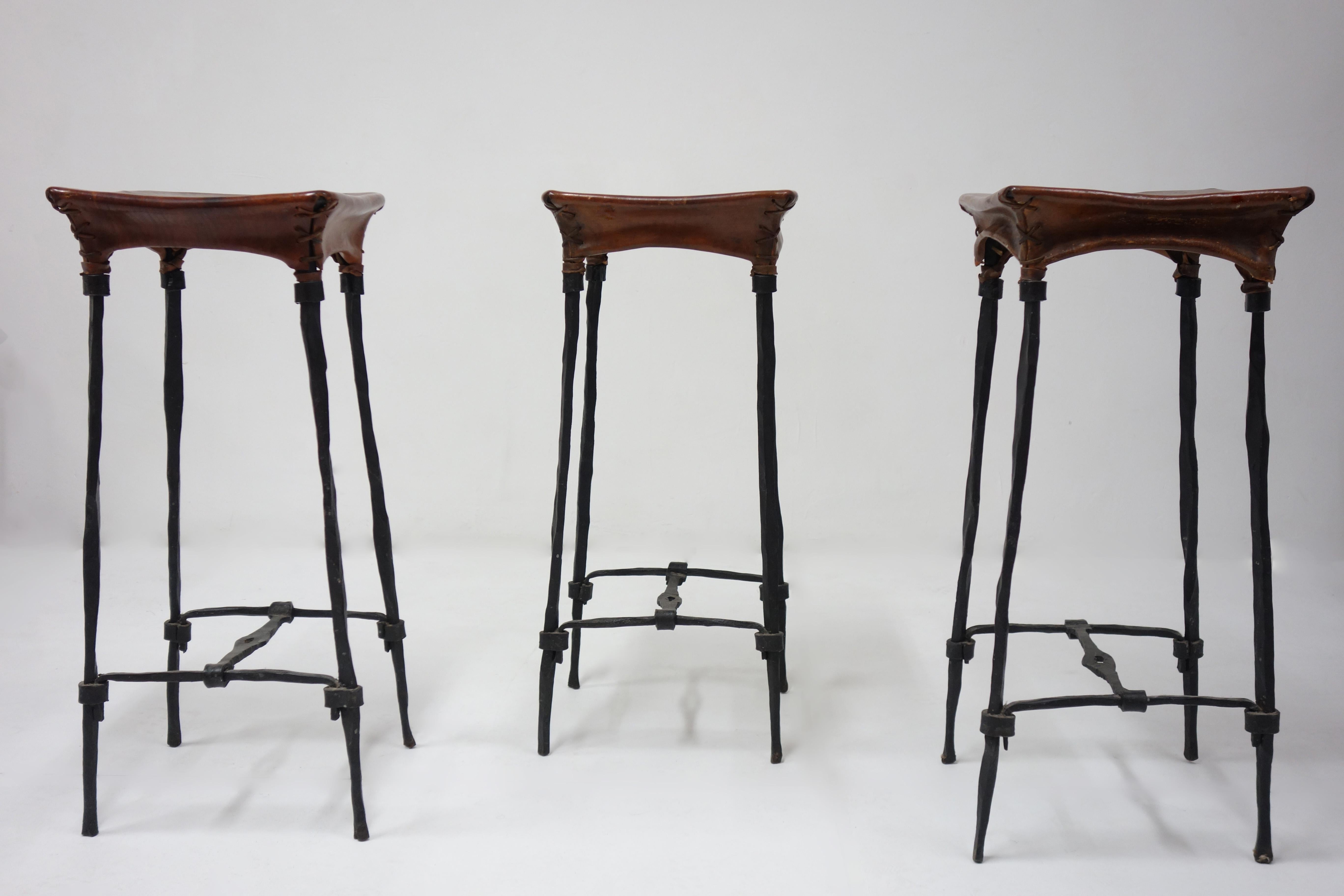 Set of 3 bar stool by François & Sido Thevenin with a black wrought iron structure and avbrown patina leather. François and Sido Thevenin give life to metal thanks to their great mastery of forging. This model is rare in this bar stool version. 
 