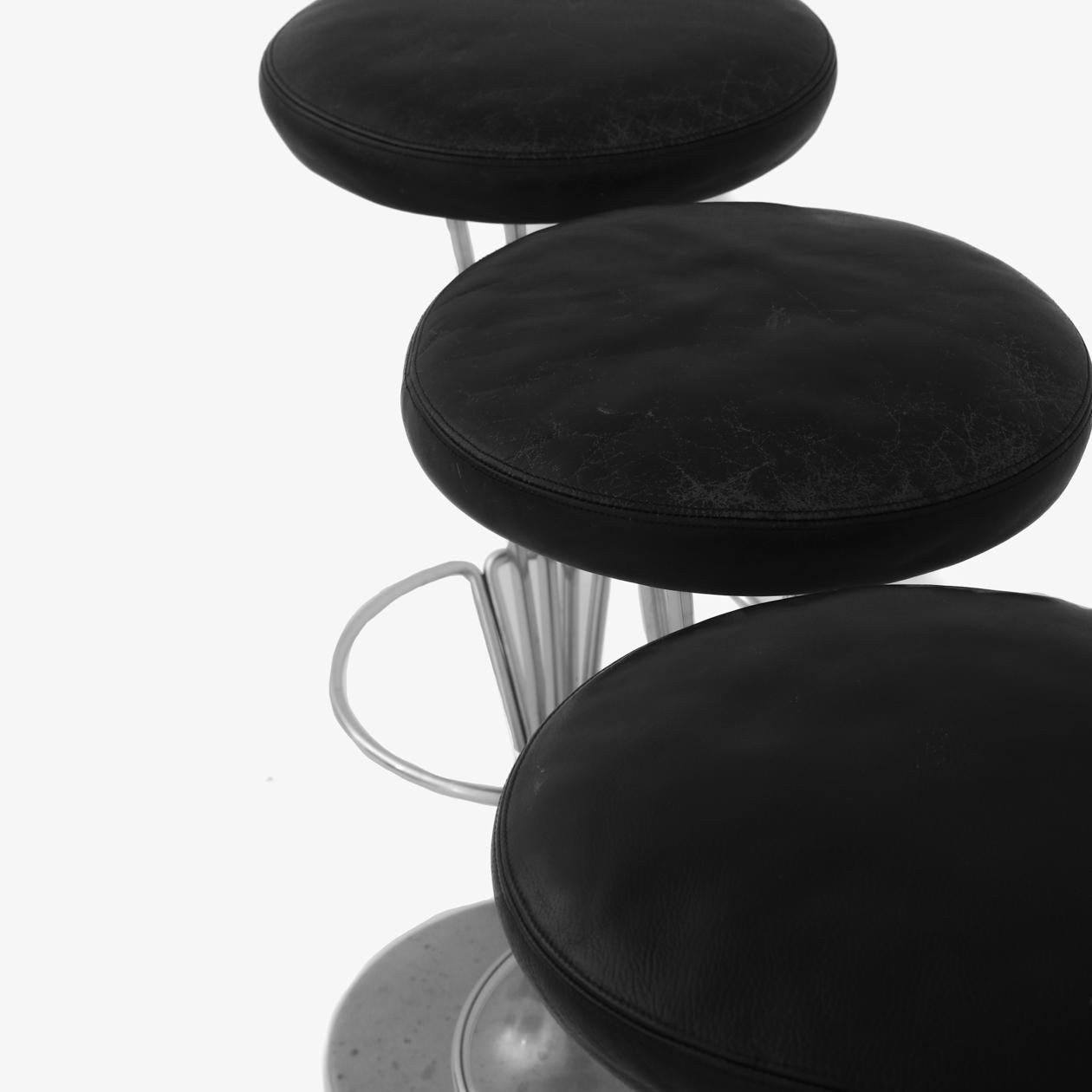 3 bar stools in original patinated black leather on steel frame. Piet Hein / Fritz Hansen.