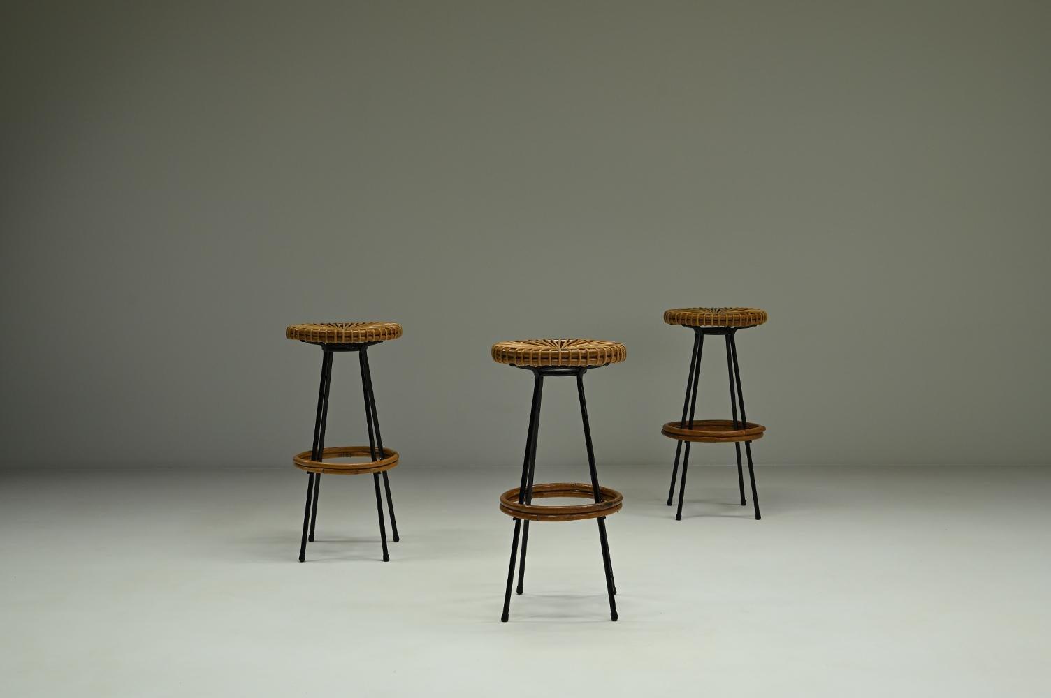 Set of 3 bar stools from Rohé Noordwolde, 1960s The Netherlands. Black laquered metal frame with rattan seat and footring. The black laquered frame gives a nice contrast to the rattan. The Rattan has rich and warm color. Many times mistaken as a
