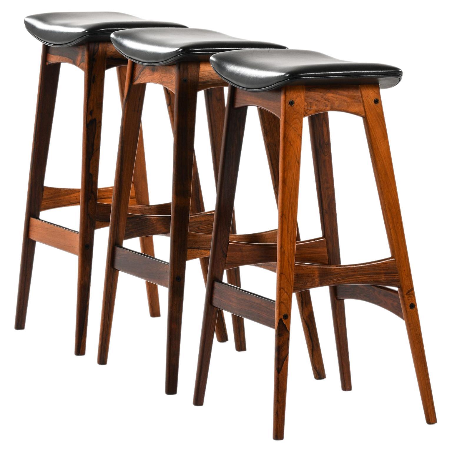 Ensemble de 3 tabourets de bar en bois de rose et cuir noir par Johannes Andersen, 1961 en vente