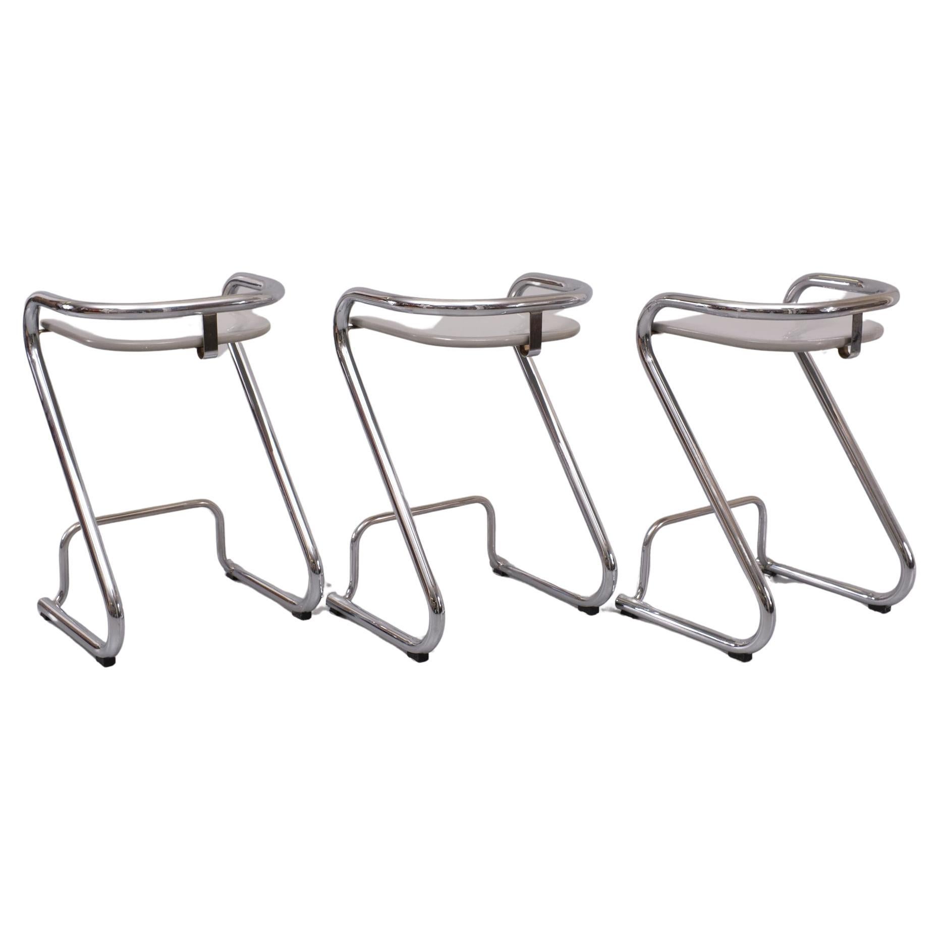 The set of 3 bar stools S 70-3, designed by Lindau and Lindekrantz in 1968 for Lammhults, is in very good condition. The curved chrome is perfect, as are the iGrey colored Wooden seat shells. Early 1960s version Lammhults is a Swedish manufacturer