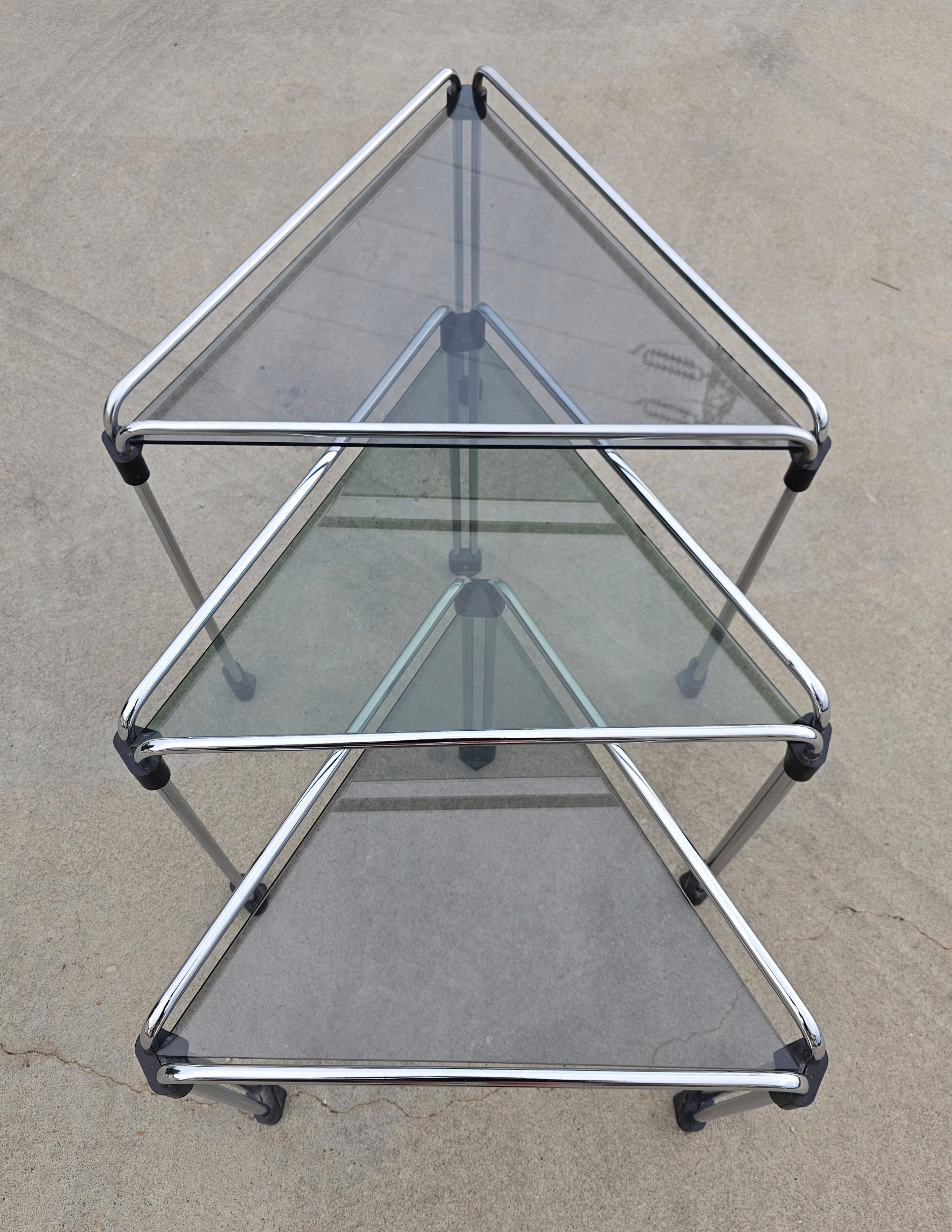 This listing features vintage set of 3 beautiful triangular mid century modern chrome and tinted glass nesting tables done in Bauhaus style. Perfect for small apartments or corner areas in your home and very stylish and elegant. 

Italian sleek