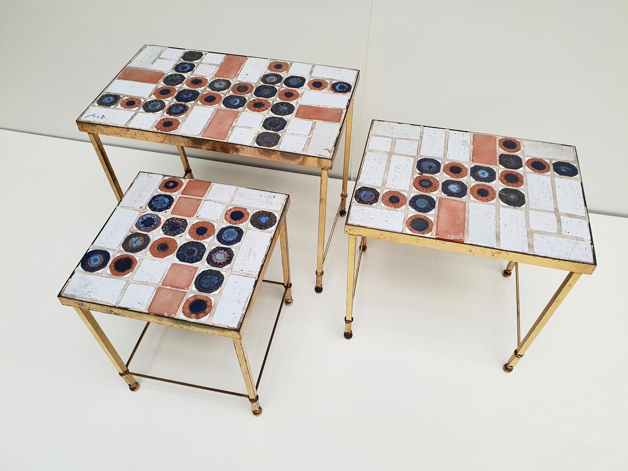 A set of 3 vintage Belgian ceramic nesting tables with polished brass frame. They were made in Italy and signed but unreadable.
Measure: Height 47 - 42 - 39 cm.
Width 57 - 41 - 31 cm.
Depth 31 - 31 - 31 cm.