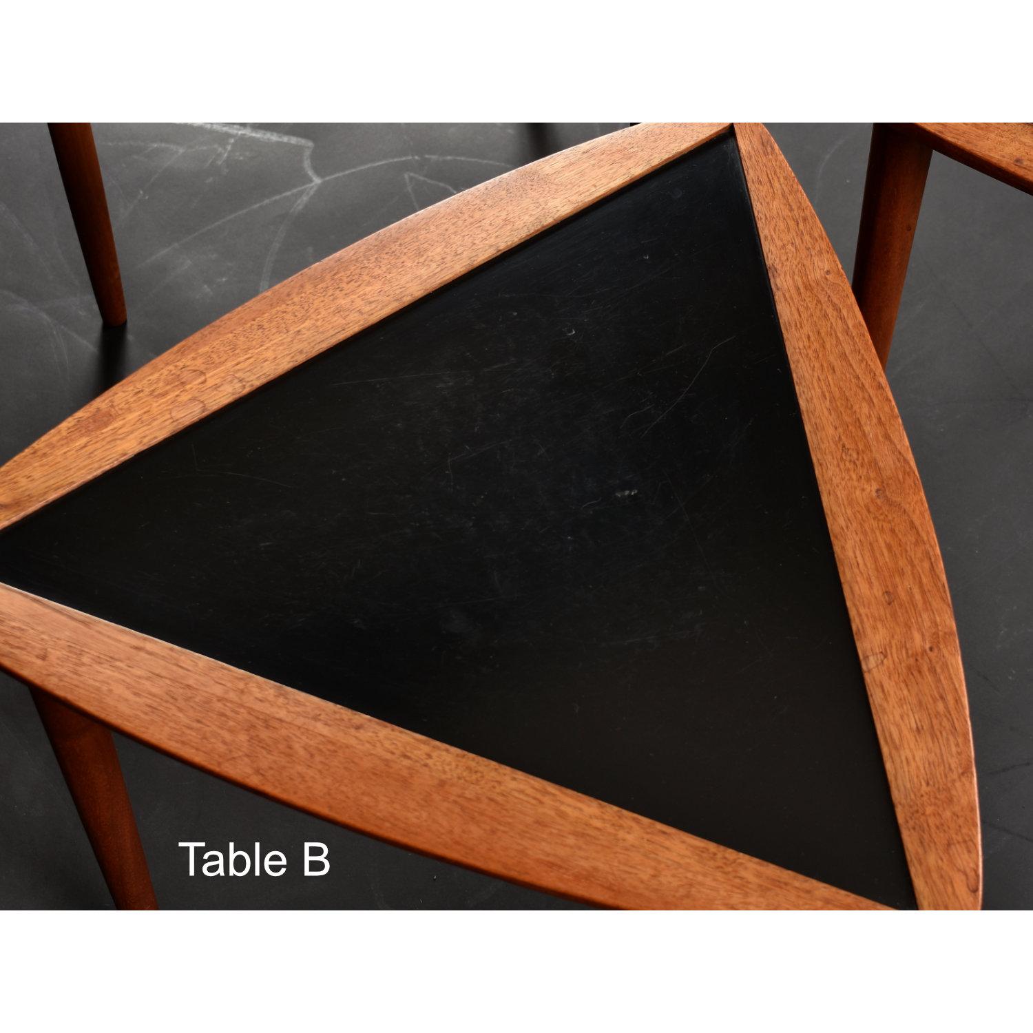 Set of three Mid-Century Modern nesting tables by Arthur Umanoff. The tables are guitar-pick shaped with black laminate tops inset to solid walnut wood frames. The vintage 1950s triangular tables can be used independently. Stack the nesting tables