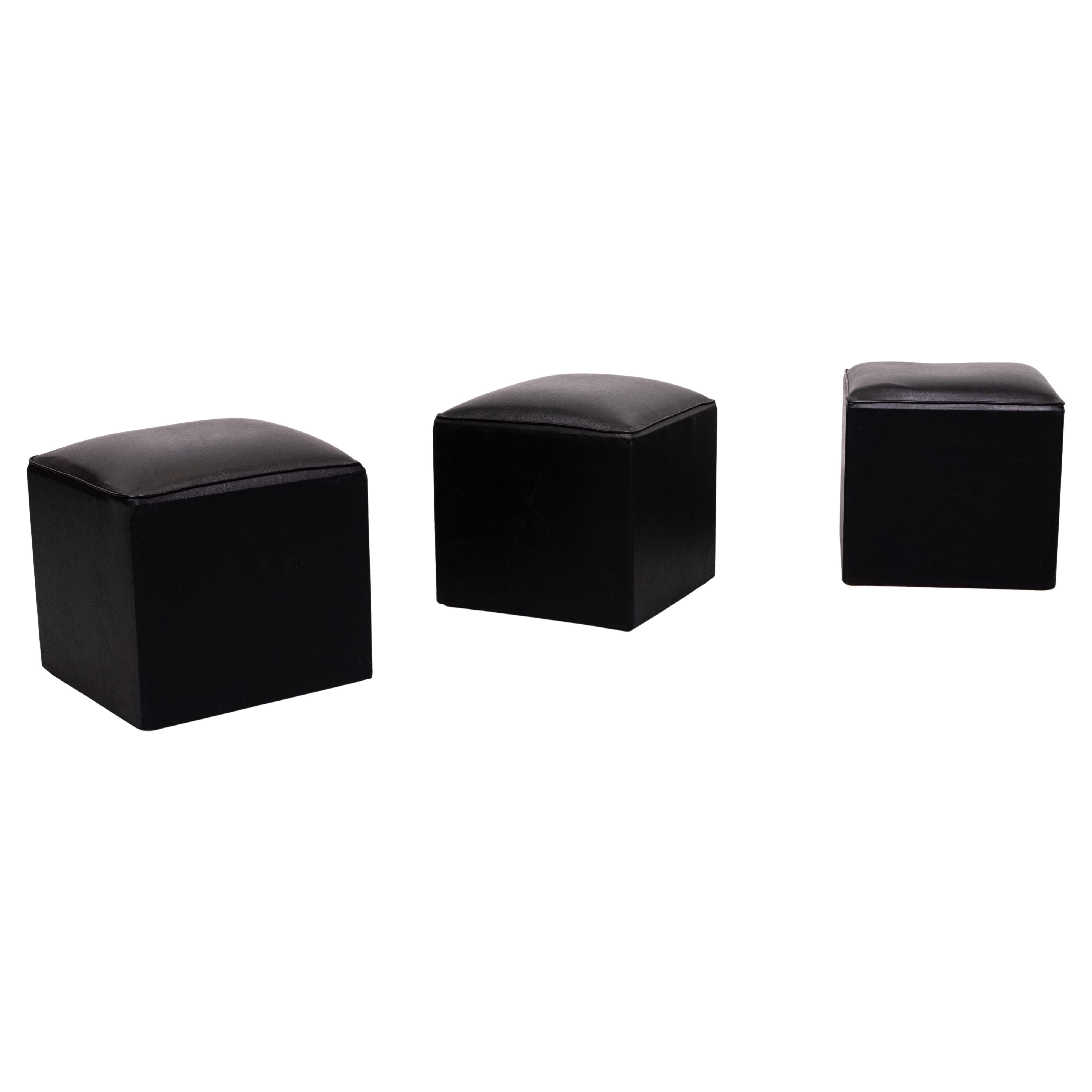 Muy bonito conjunto de 3 pequeños taburetes u otomanos cúbicos idénticos  .                            Tapicería de piel sintética negra .
Buen estado . 1960s 
Los pufs en forma de cubo Link tienen el tamaño perfecto para que los invitados tomen