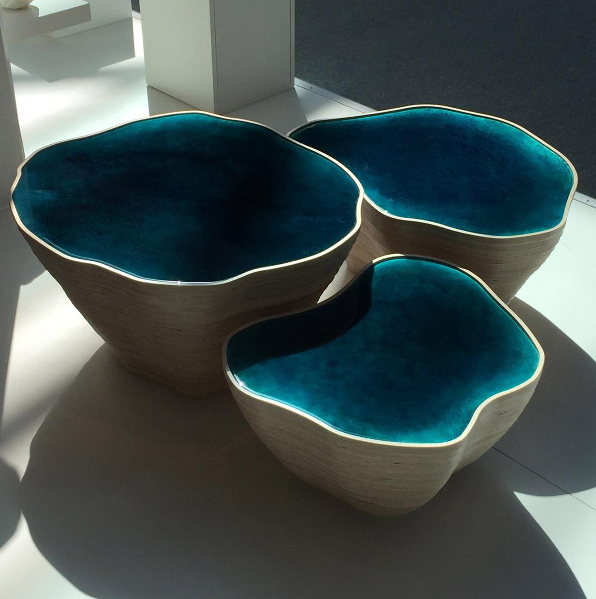 A designer's creation composition of three Blue coffe center tables and  or stools of different dimensions,  inspired by the Russian dolls and by the nature, the rocks  and sea of Bretagne's French region, with sensual and soft curves as the
