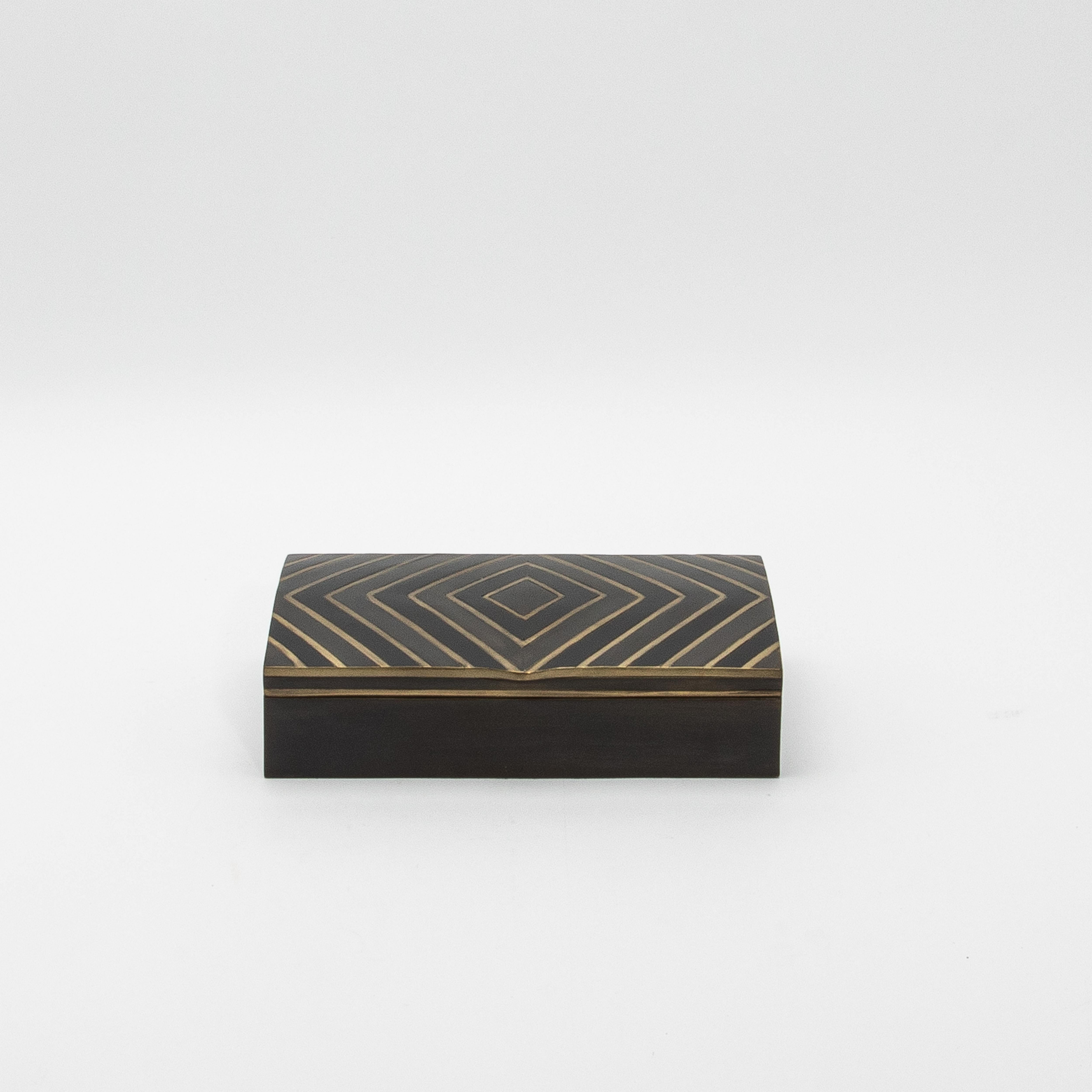 Este juego de 3 cajas de R&Y Augousti es una muestra magistral de lujo y artesanía, que combina el roble negro con intrincados detalles de latón. El elegante motivo geométrico en zigzag, meticulosamente incrustado con pátina de bronce y latón