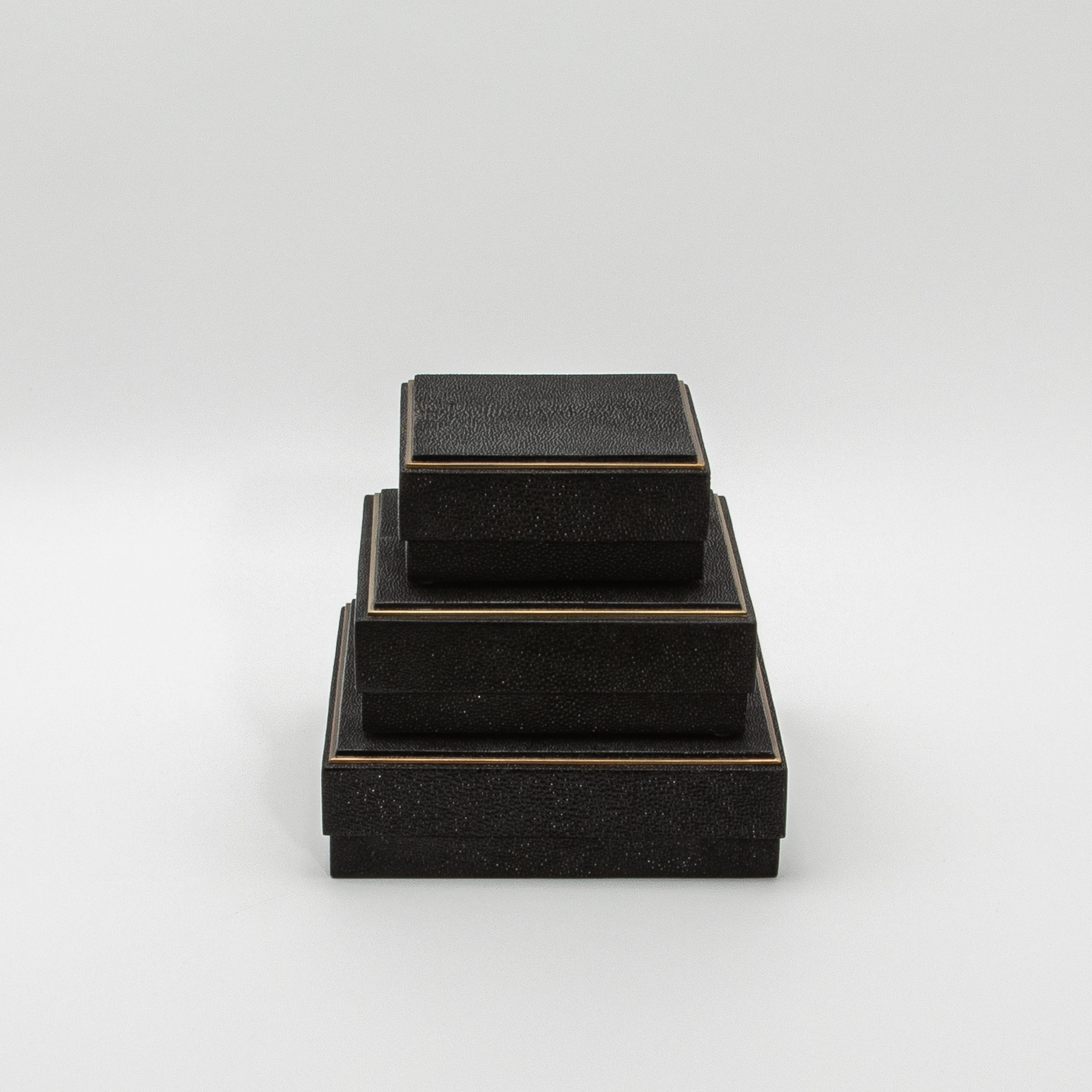 This set of three square boxes by R&Y Augousti is a masterclass in luxury craftsmanship, merging sleek design with sumptuous materials. The textured black shagreen wraps each piece, providing a sophisticated, tactile surface that exudes understated