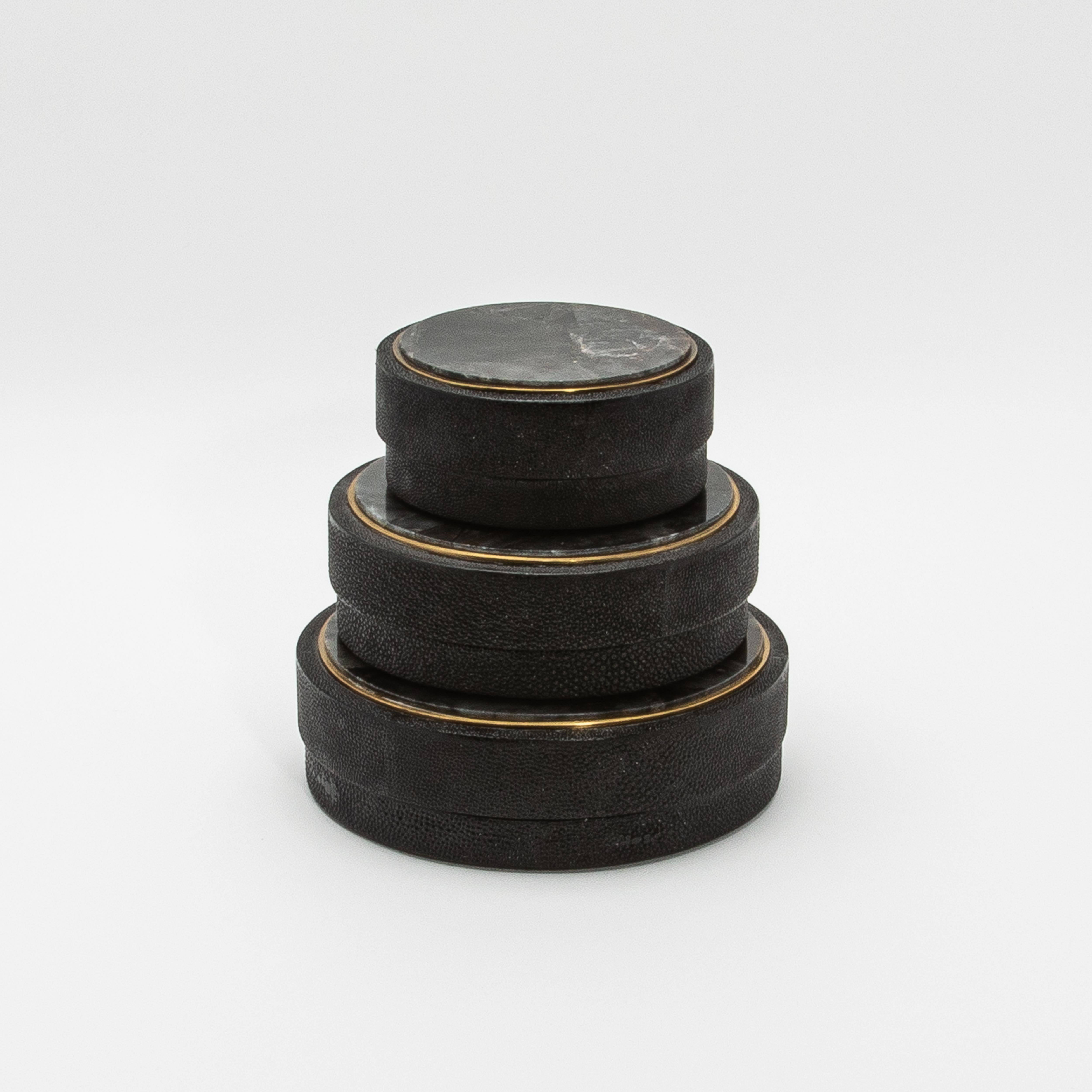 Este juego de tres cajas redondas de R&Y Augousti es un impresionante ejemplo de arte moderno mezclado con lujo atemporal. Las tapas están adornadas con rico cuarzo negro, cada pieza muestra un veteado único que capta la luz maravillosamente,