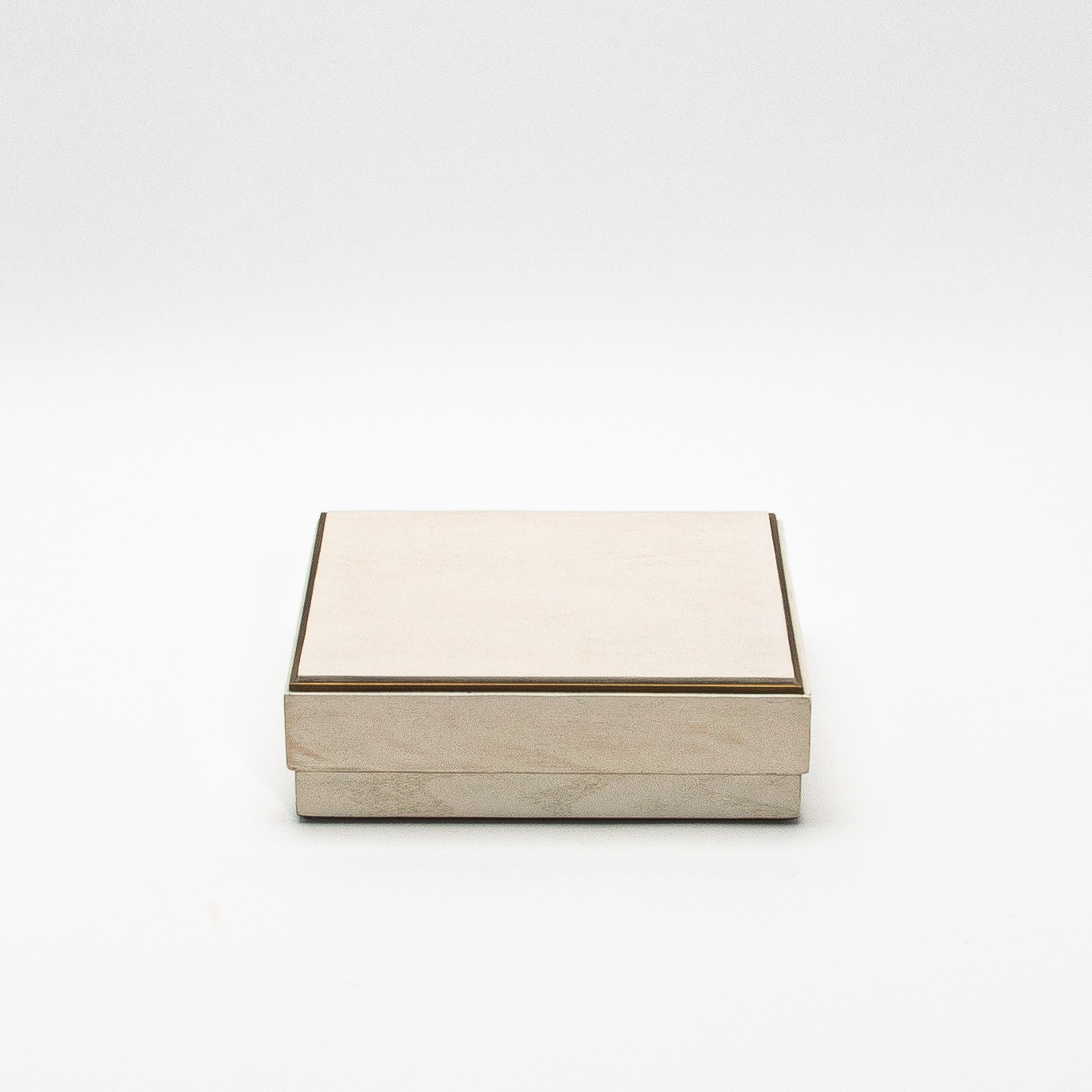 The set of three square boxes in white oak with a brass frame by R&Y Augousti presents a refined yet minimalist design that exudes modern luxury. The rich white oak wood is meticulously handcrafted, showcasing the natural grain of the wood for a