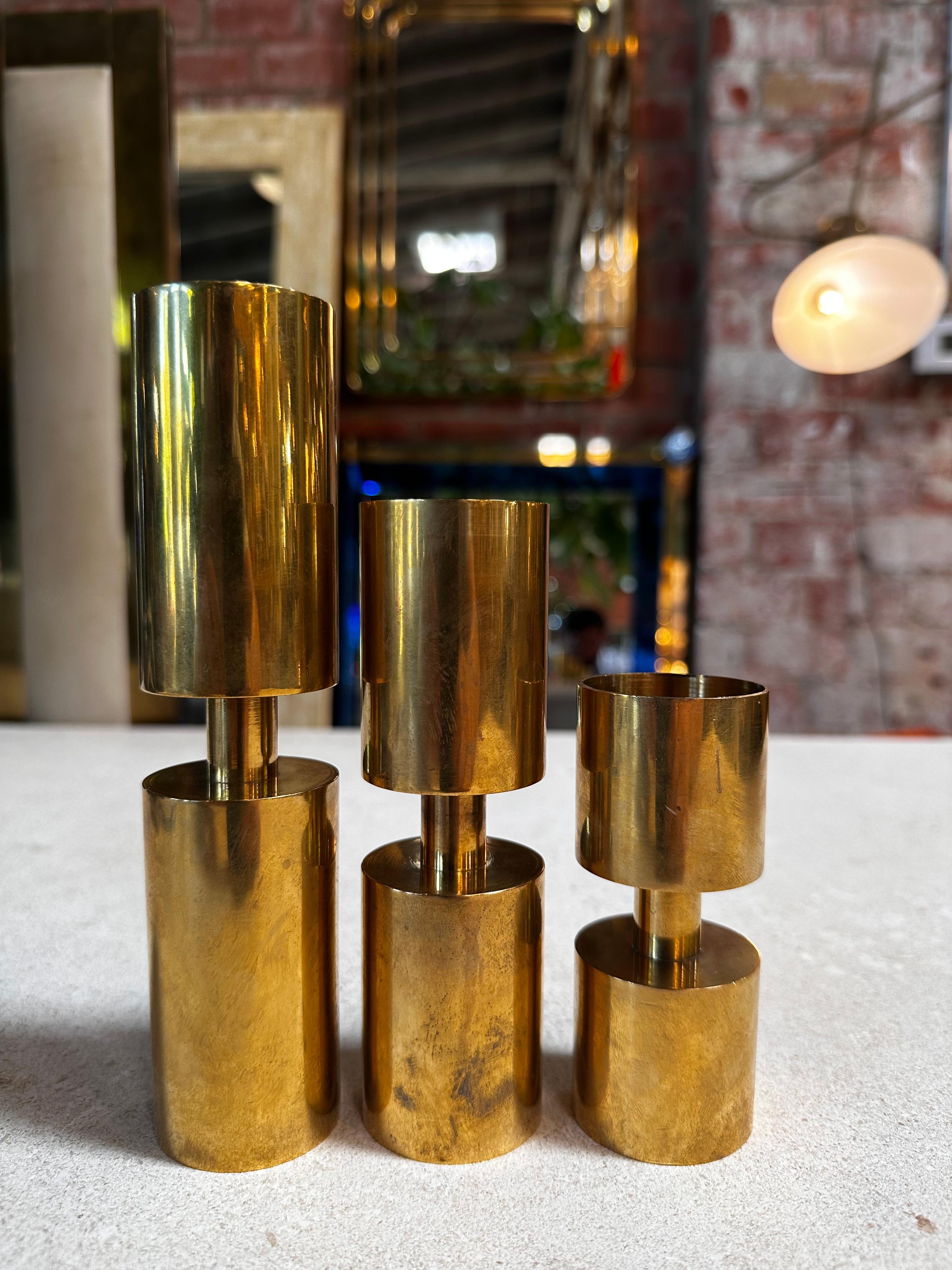 Crafted in the 1970s, this set of three brass candle holders designed by Thelma Zoéga for Zoégas Kaffe is a fusion of artistry and functionality. Reflecting Scandinavian design sensibilities, these pieces capture the essence of the era with their