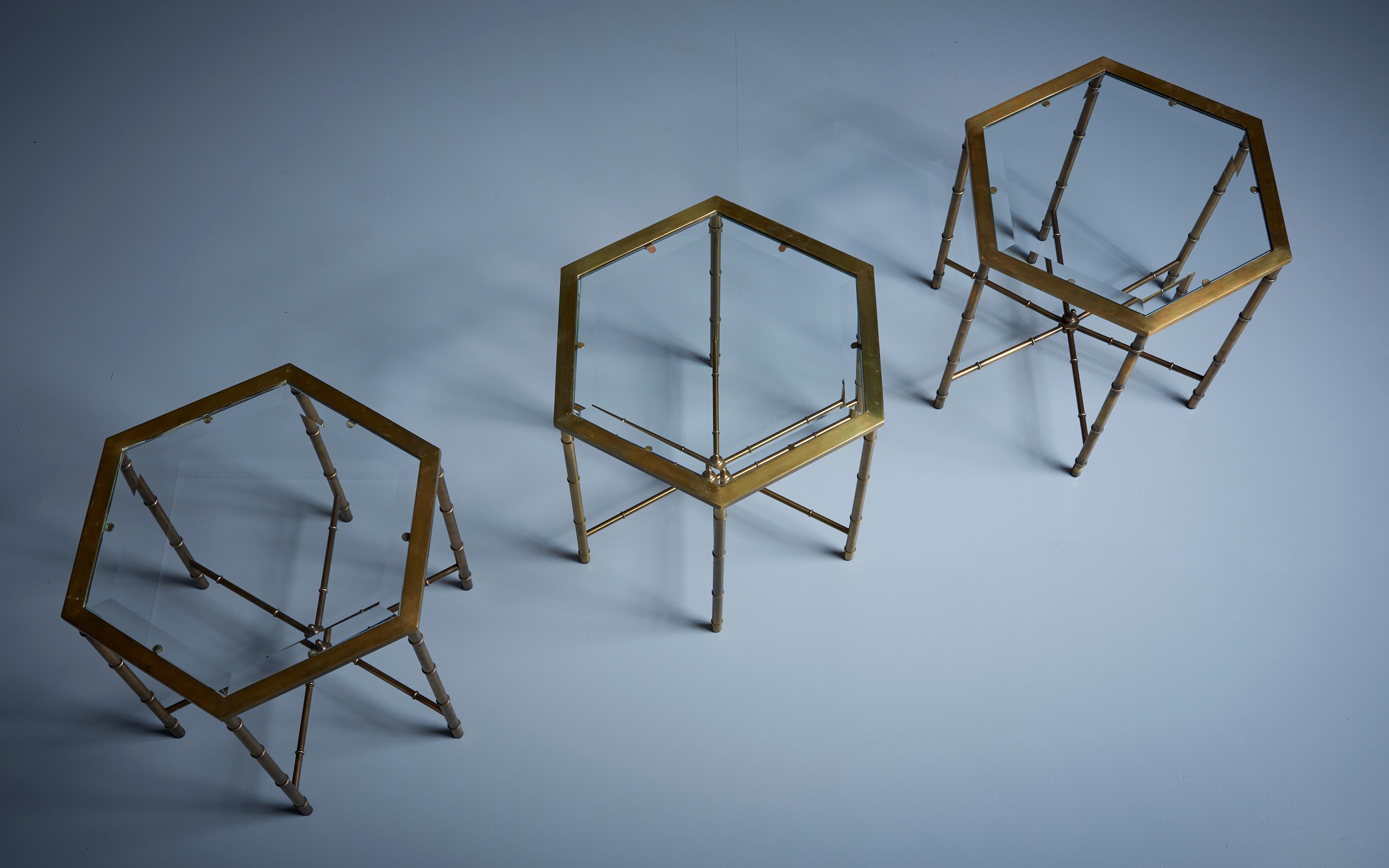 Beautiful set of 3 faux bamboo side tables in brass with a glass table top. The tables are attributed to Maison Bagues and in good condition.