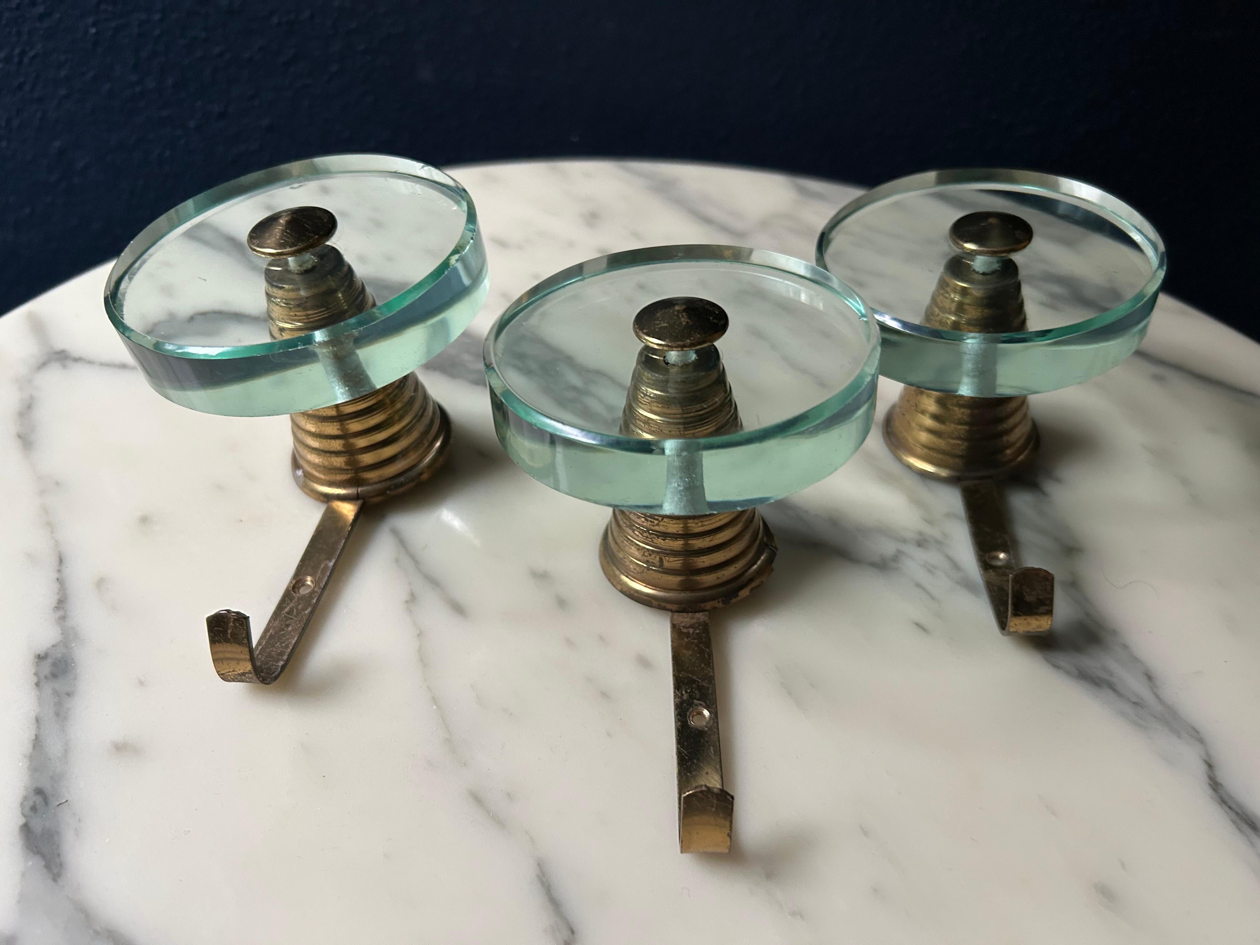 Abbiamo scoperto questo set di tre eleganti appendiabiti con vetro di cristallo su una cornice in ottone durante un recente viaggio nel Nord Italia!

Molto probabilmente proveniente dalla celebre manifattura italiana Fontana Arte, questo set è stato