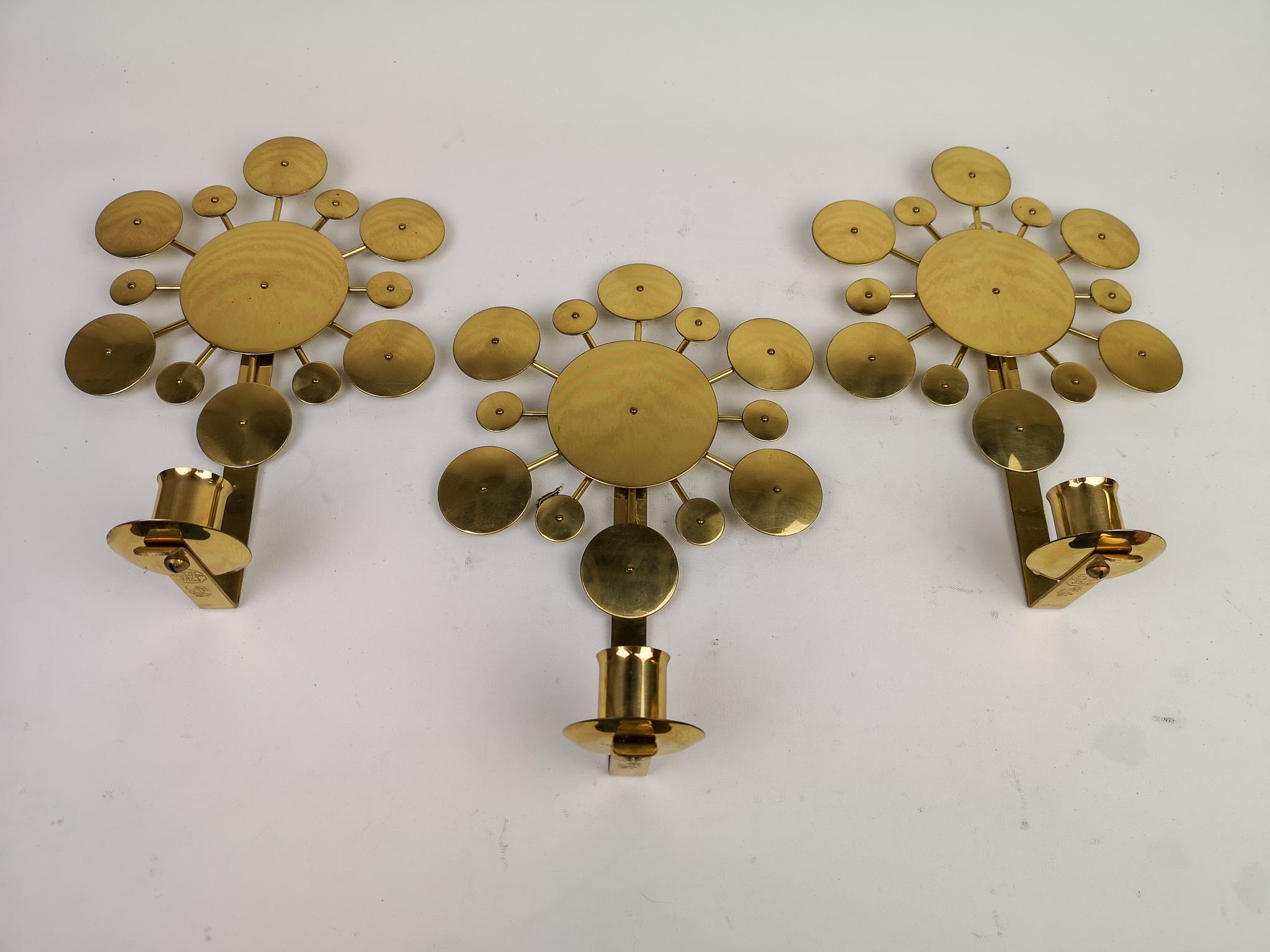 These wall candlesticks were hand -sculpted in Arvika, Sweden. The candlesticks are made in brass by famous Holmström Arvika. These ones are signed on the back. The name Sunburst was given to the candlesticks because of middle sun is surrounded with