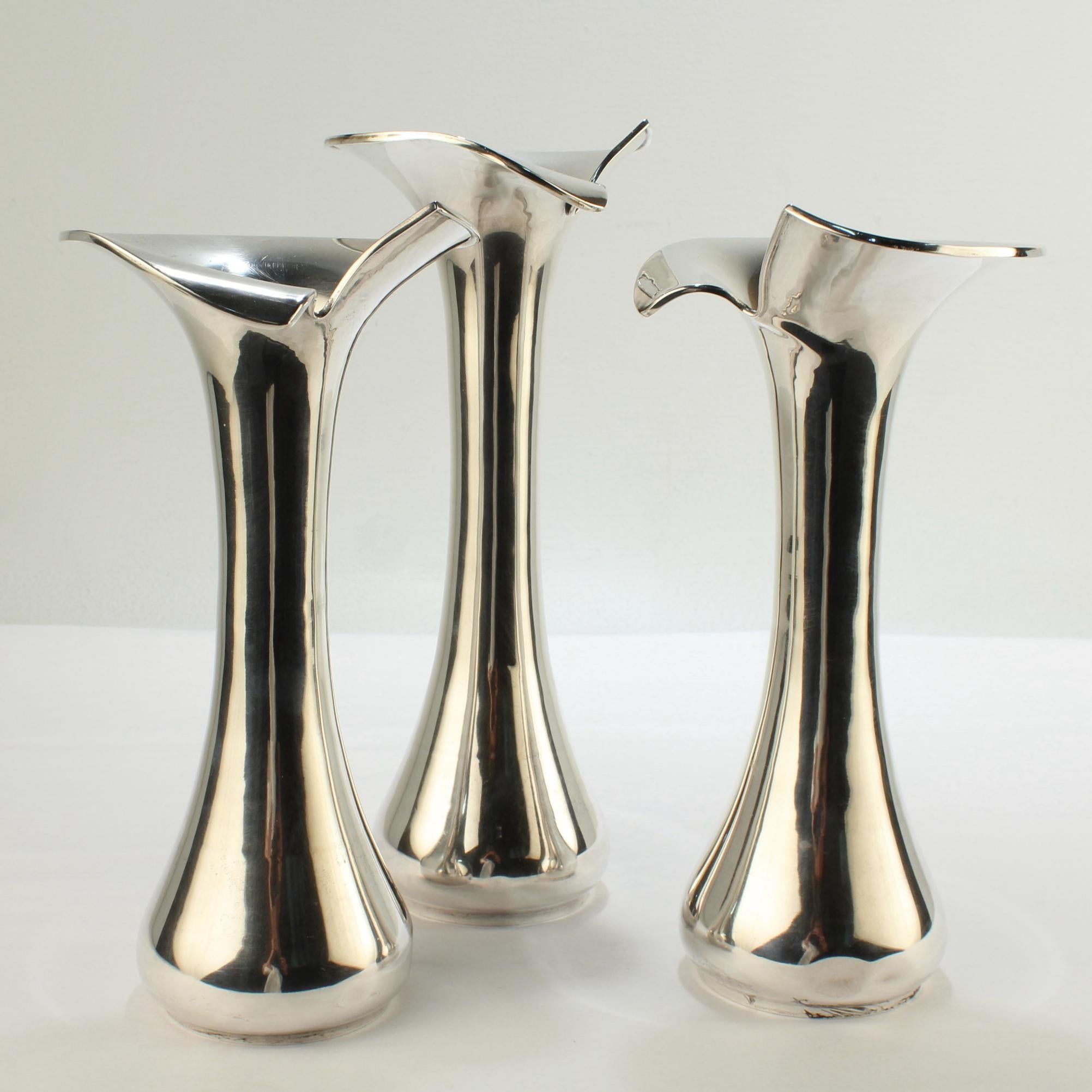 A fine group of 3 Modernist solid silver.

Each in .900 fineness silver with a 'split' trumpet form top, a tapered body and a rounded foot.

We believe that these vases are quite likely Brazilian. Each is struck with an R that we believe is likely