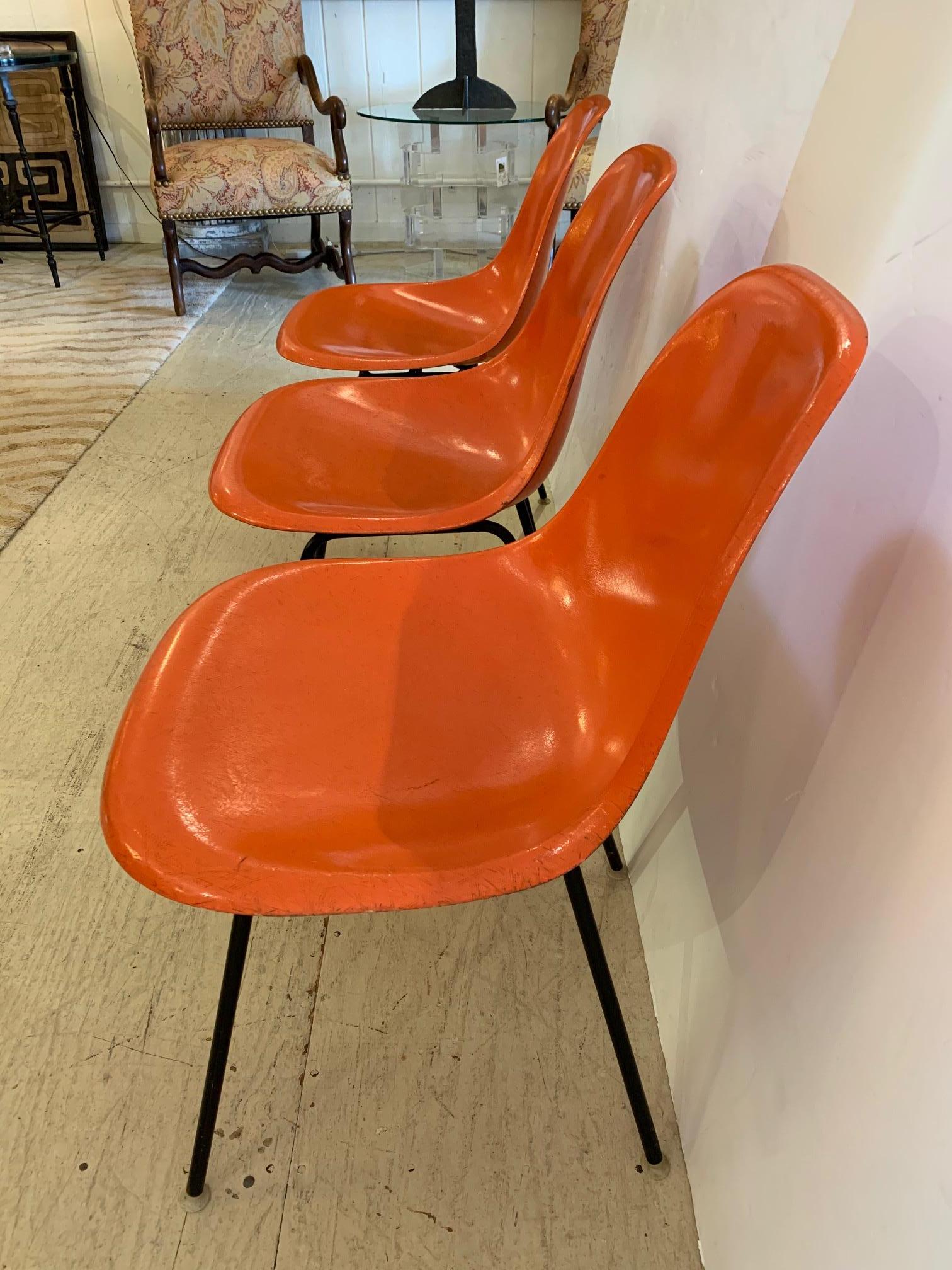 The Classic DSX fiberglass chair designed by Charles Eames for Herman Miller having a bright orange color and black H bases. Each shell is stamped with the Herman Miller emblem underneath.

Measures: Seat height 17.5
Seat depth 15.5.