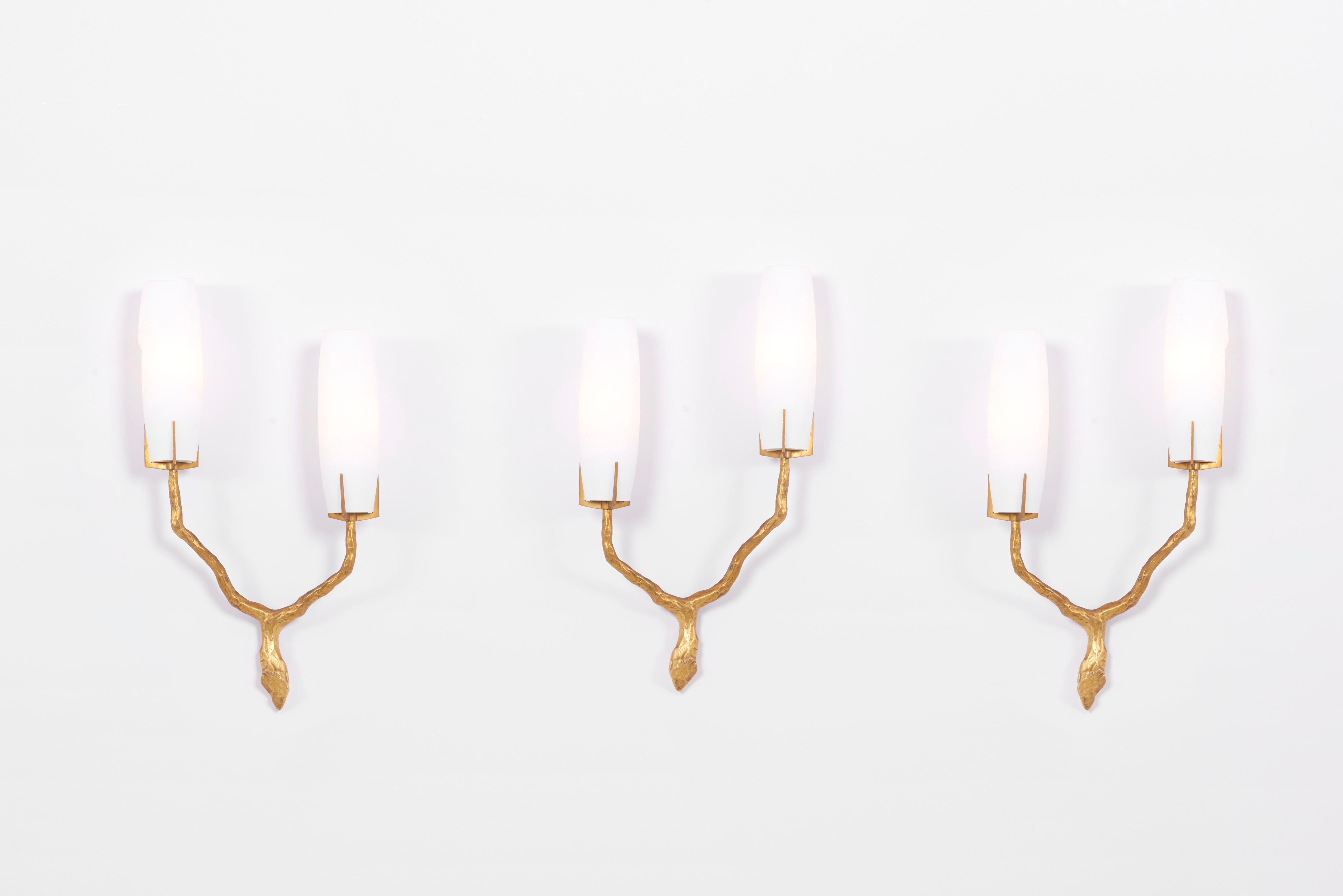 Stunning set of three cast gilt bronze wall appliqués with silk opaque glass shades. Each with a two-arm branch.
Based on a drawing by Felix Agostini and manufactured by Maison Arlus, France in the 1960s.
Old French bayonet sockets - should be