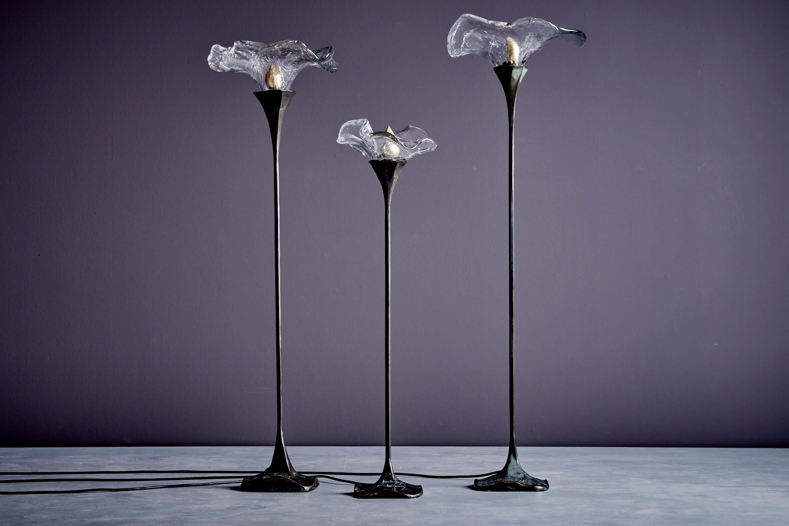 Bellissimo set di tre lampade da terra scultoree dell'artista tedesco Lothar Klute. Ogni lampada è dotata di un paralume in vetro modellato a mano con una forma organica e floreale. Le basi sono realizzate in bronzo fuso massiccio con un'esclusiva