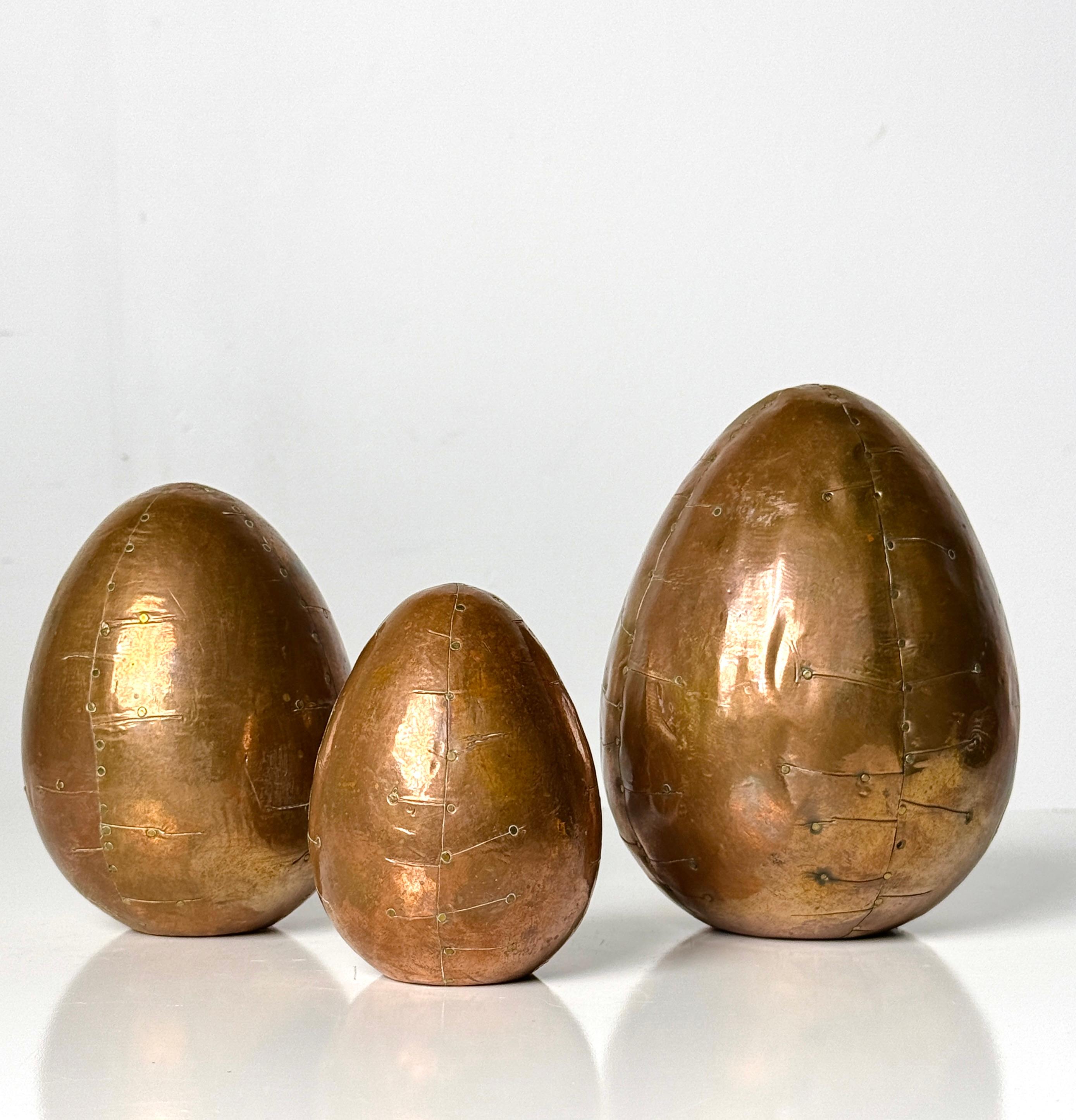 Grouping of three stylized copper egg sculptures circa 1990s

Patchwork copper clad eggs of graduated sizes fastened with brass rivets
Unmarked

3 - 5 inch diameter
4 - 6.25 inch height 