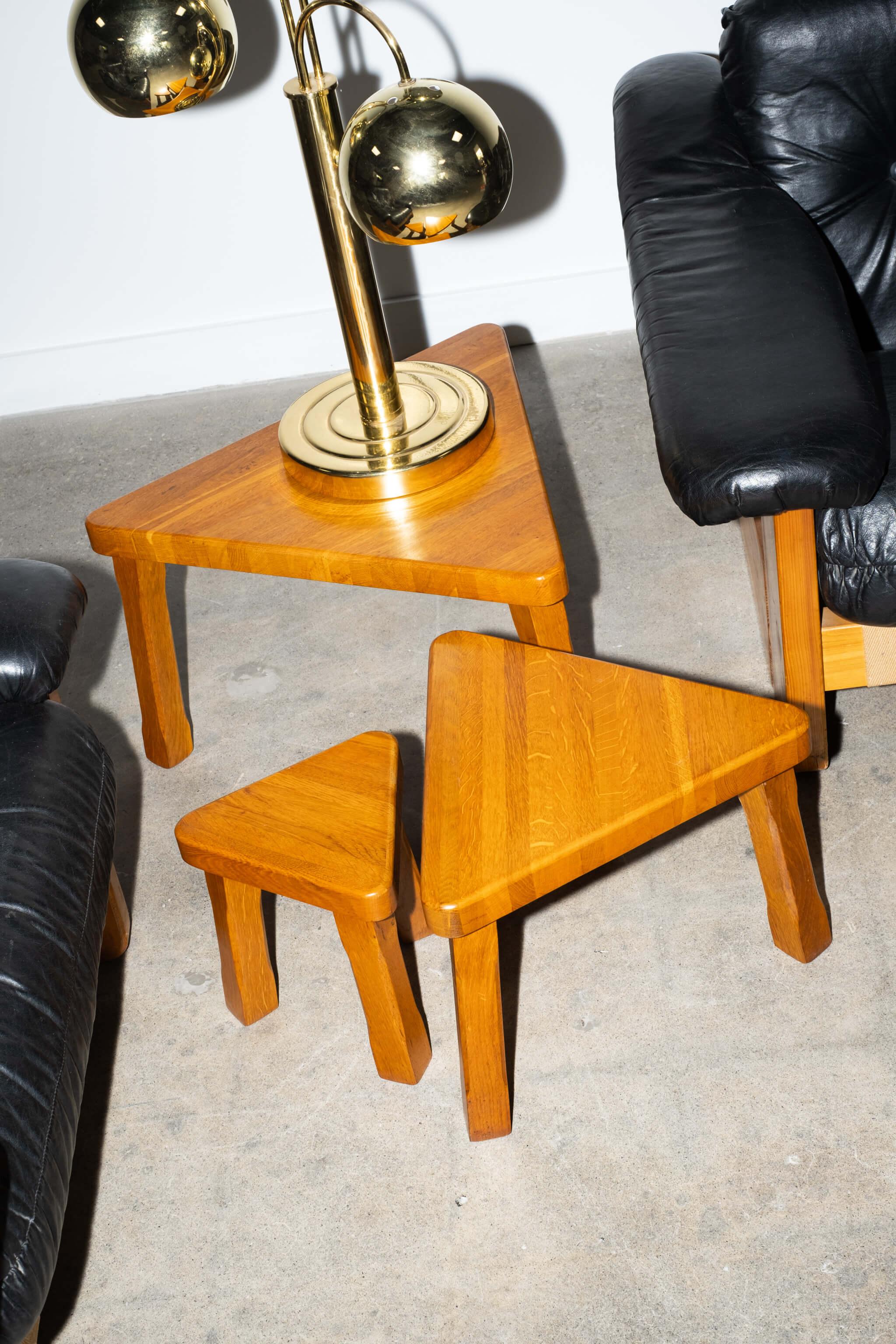A set of three triangular-shaped nesting tables in a warm solid oak, on sturdy tripod legs. 1950s, in the style of French master Pierre Chapo - whose passion for wood and modernist designs were heavily focused on craftsmanship. Useful, elegant and