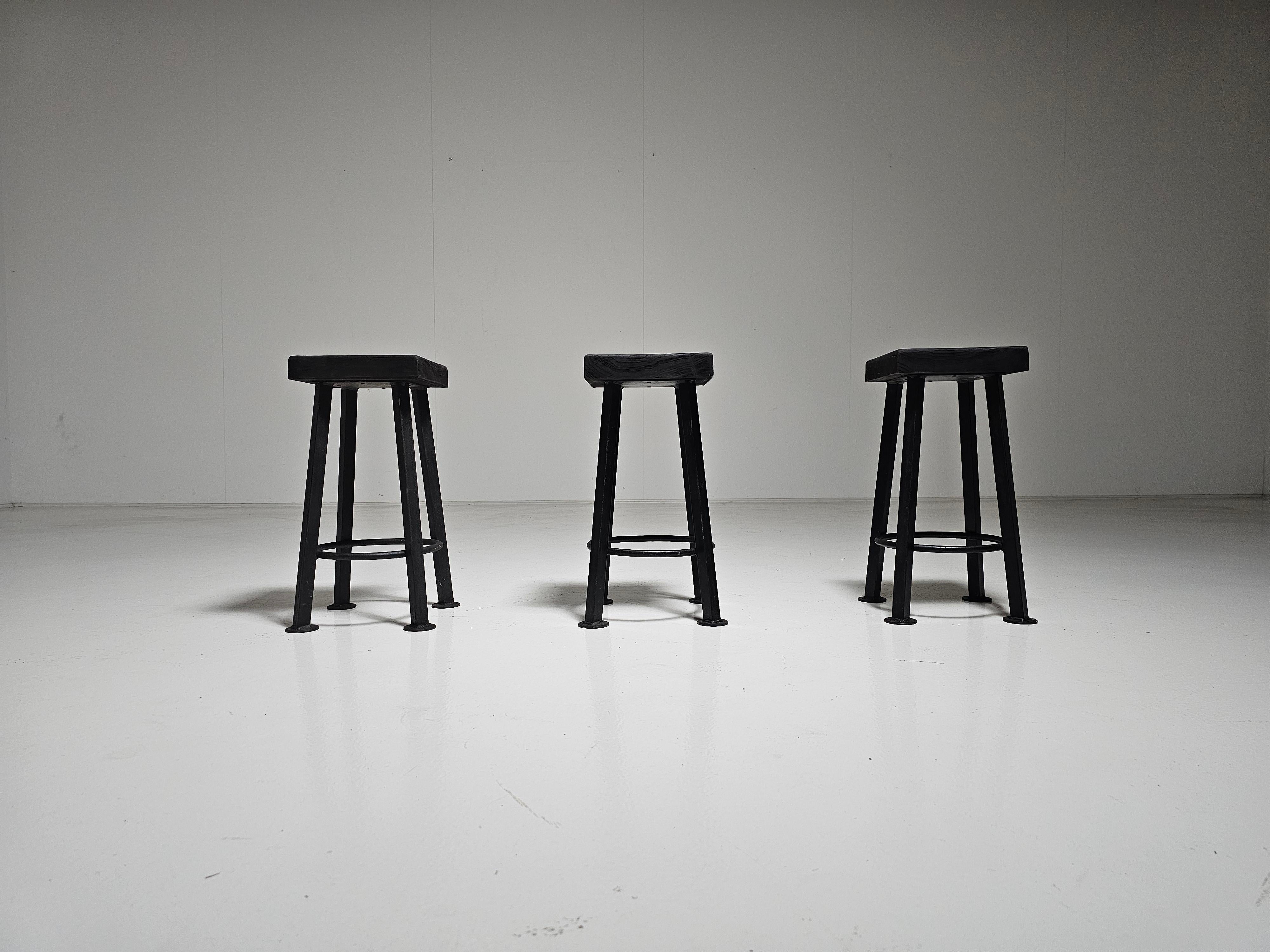 Handmade set of trhee Belgium brutalist stools from the 1970s. Solid painted wooden seats with a black coated steel base. The wood and steel gained a patina through the years. They are still in very good condition. Strong and stable to be used as