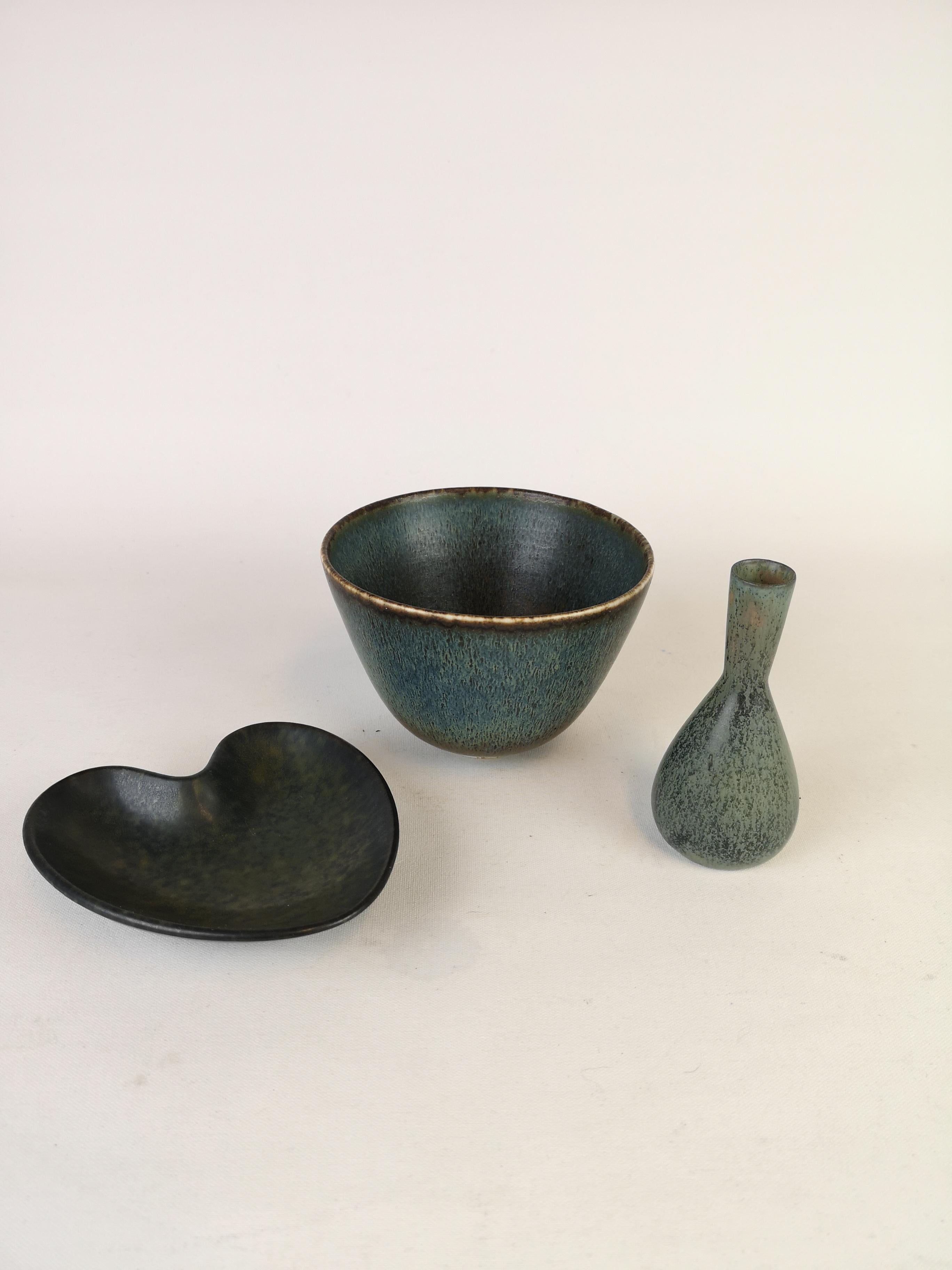 Set of 3 pieces made by Gunnar Nylund and one by Carl-Harry Stålhane. The bowl and the heart shaped bowl are made by Gunnar Nylund and the small vase is made by Stålhane. 

Very good condition

Measures. Bowl H 9 cm D 13, small vase H 11 D 6