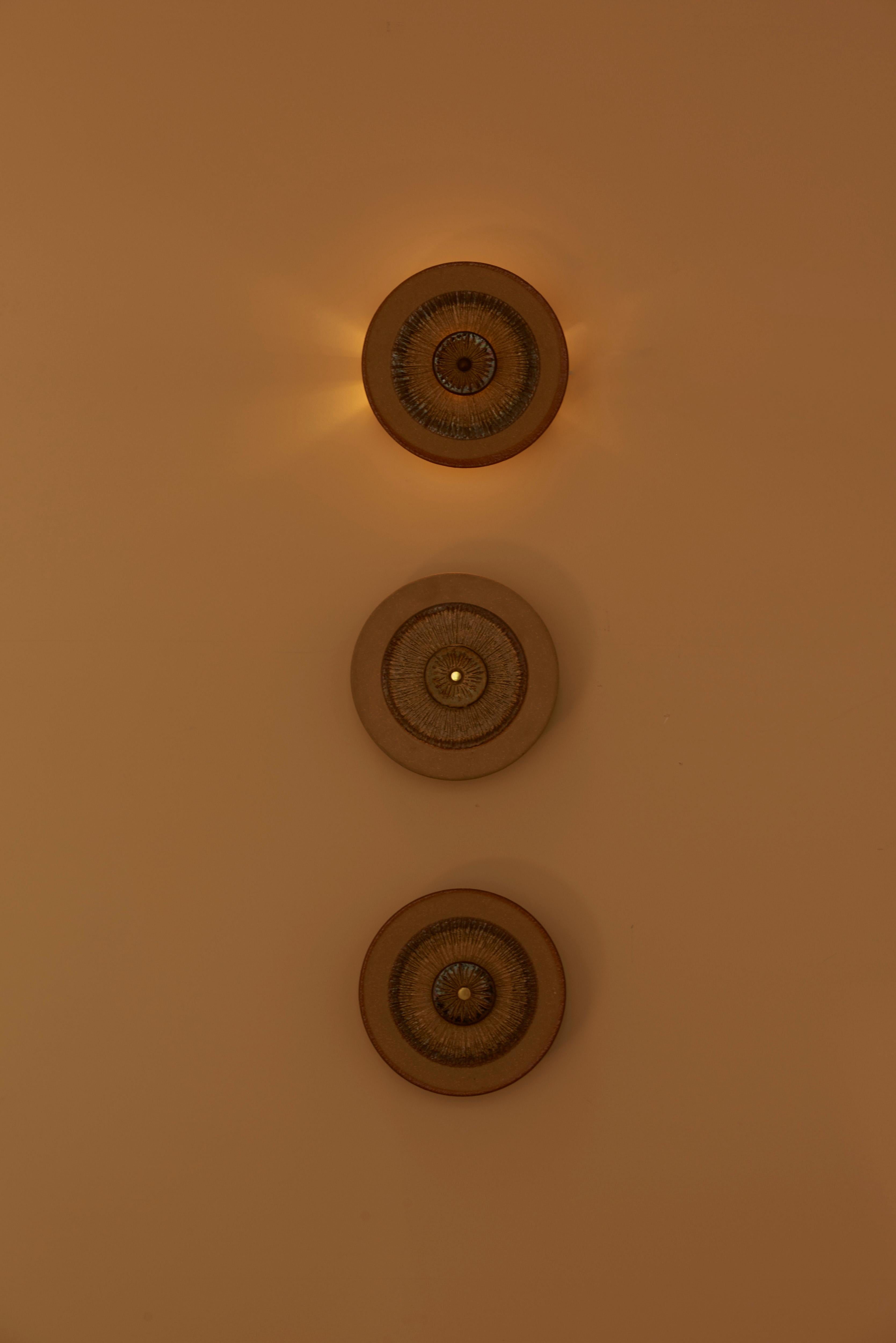 Set of 3 Danish ceramic wall lights from the 1960s designed by Noomi Backhausen & Poul Brandborg for Søholm, Scandinavian Style. The lights consist of ceramic discs with a back light. 1 x E14 each.

To be on the safe side, the lamps should be