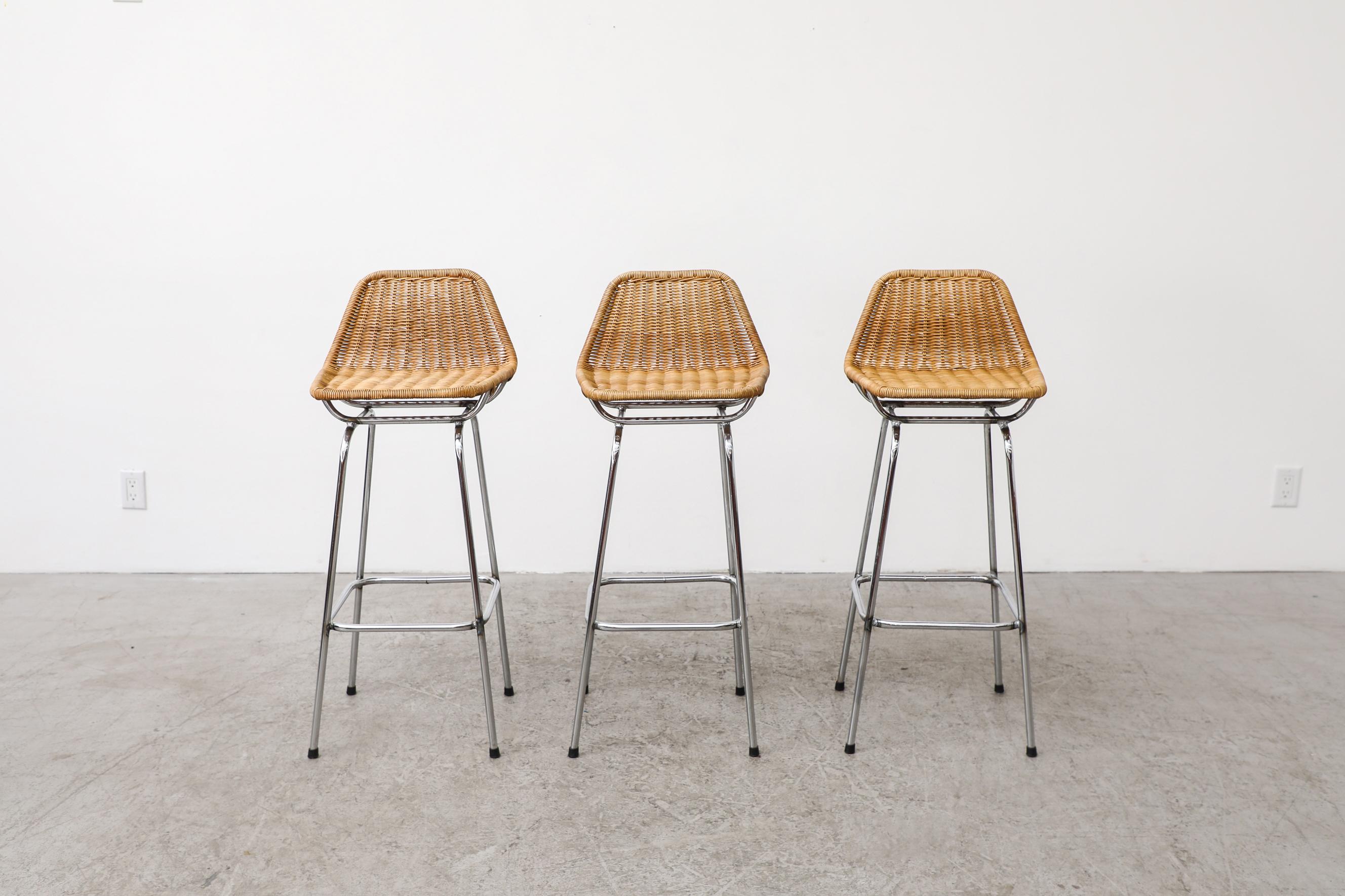 Charlotte Perriand style wicker bar stools by Dirk van Sliedregt for Rohe Noordwolde. These stools have chrome legs with woven wicker seats and angled backrest. In original condition with visible wear consistent with their age and use. Sold as a set