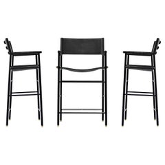 Set di 3 sgabelli da bar classici con. Schienale in pelle nera e struttura in metallo con gomma nera